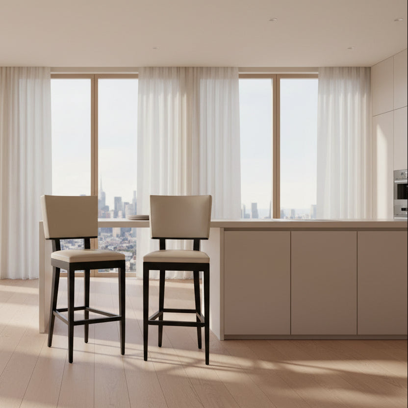 Modern kitchen featuring a minimalist luxury vibe—Christian Liagre Bar Stool Set of 2 at the counter, large windows draped with sheer white curtains, and a stunning cityscape view outside.