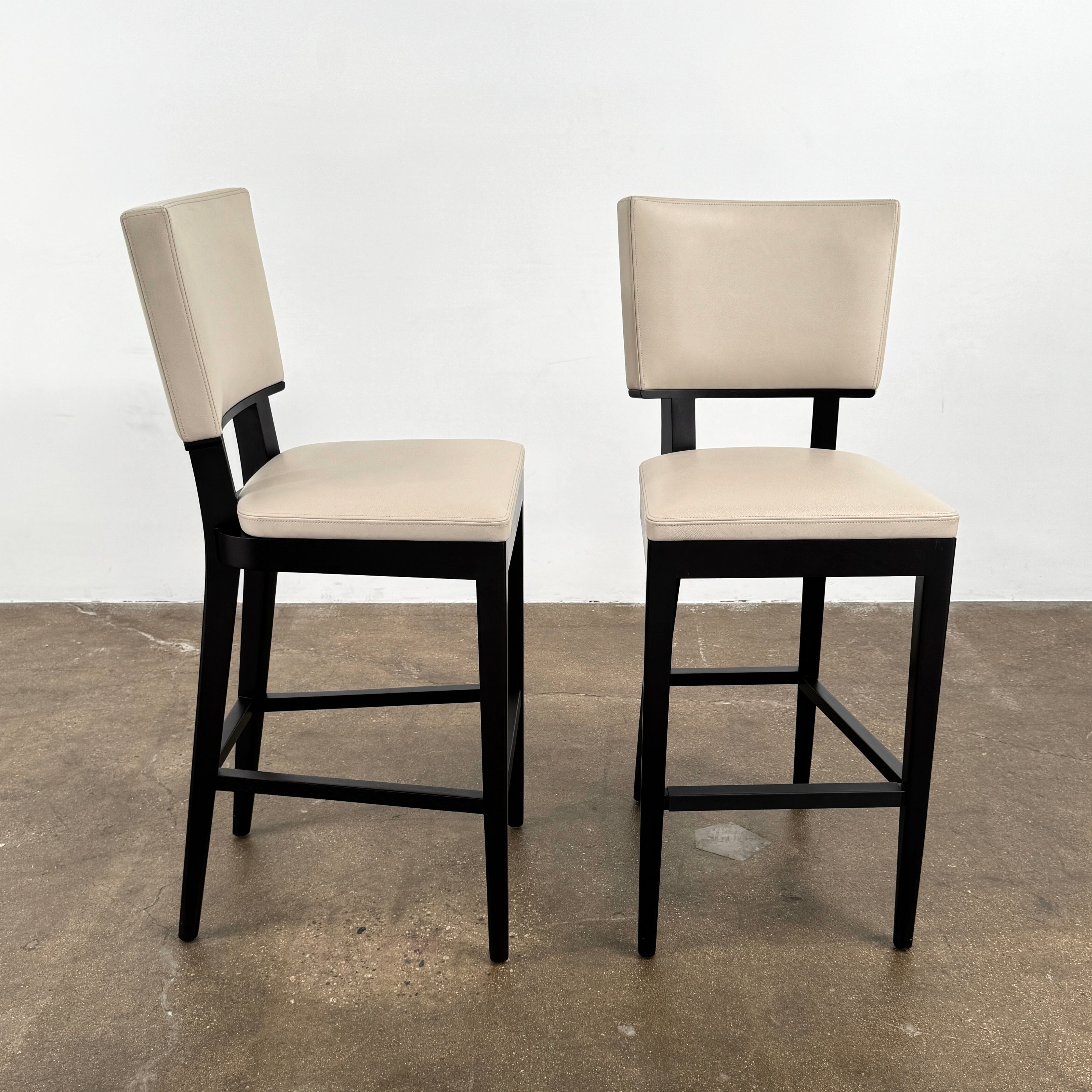 Modern kitchen featuring a minimalist luxury vibe—Christian Liagre Bar Stool Set of 2 at the counter, large windows draped with sheer white curtains, and a stunning cityscape view outside.