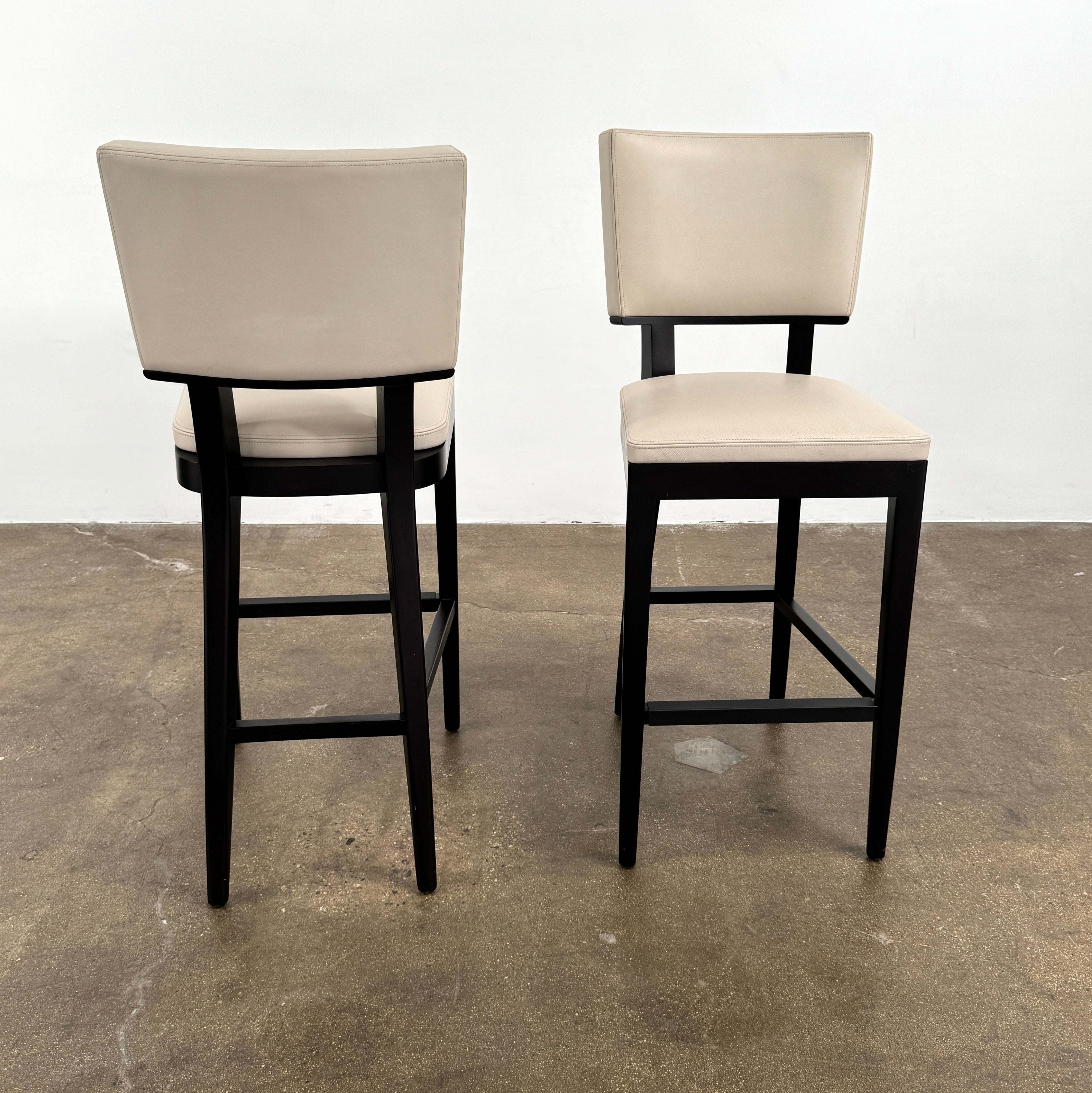 Modern kitchen featuring a minimalist luxury vibe—Christian Liagre Bar Stool Set of 2 at the counter, large windows draped with sheer white curtains, and a stunning cityscape view outside.