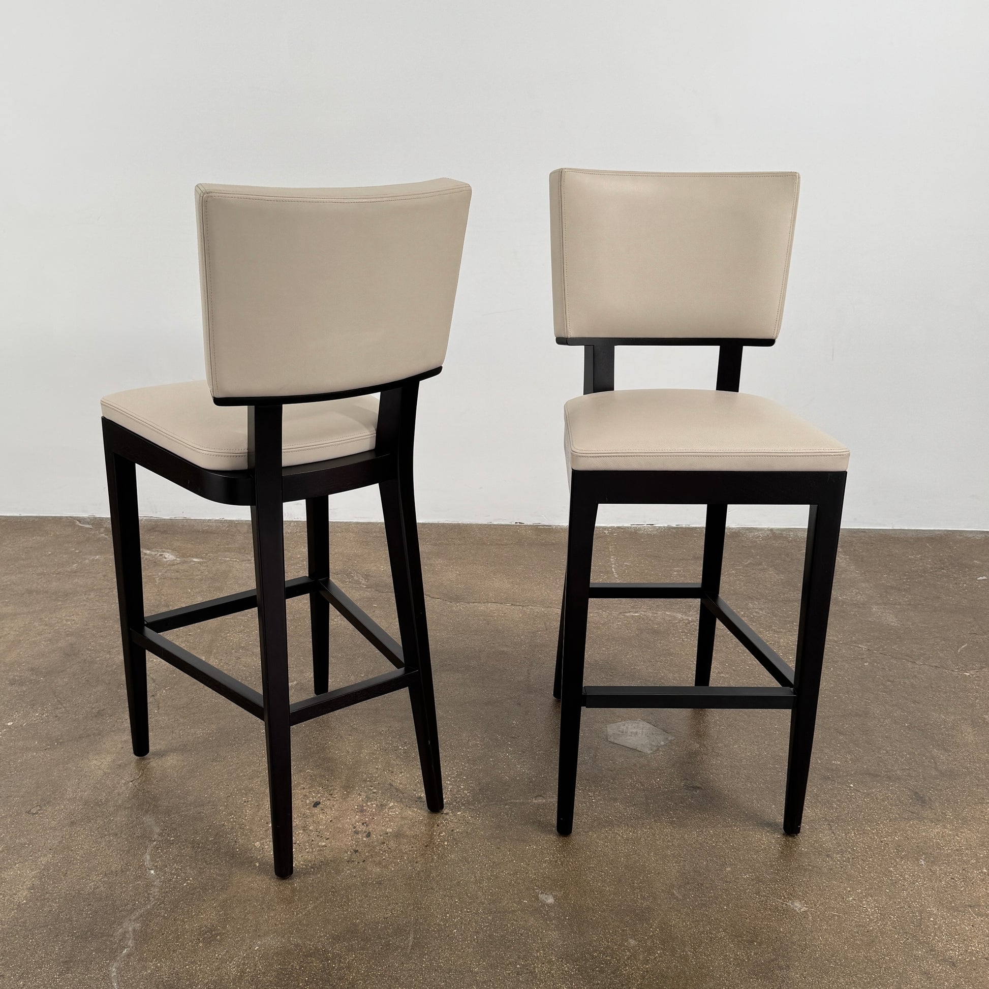 Modern kitchen featuring a minimalist luxury vibe—Christian Liagre Bar Stool Set of 2 at the counter, large windows draped with sheer white curtains, and a stunning cityscape view outside.