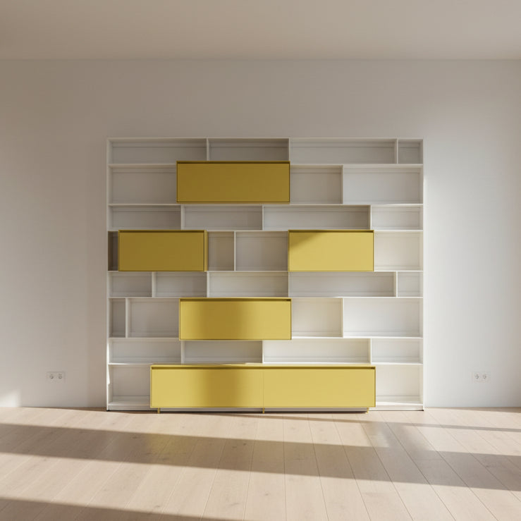 Close-up of a yellow cabinet door with a small paint chip on the bottom edge; black bowls and books are seen on a white shelf of the B&B Italia Flat C Wall Unit With Storage by B&B Italia, combining style and function.
