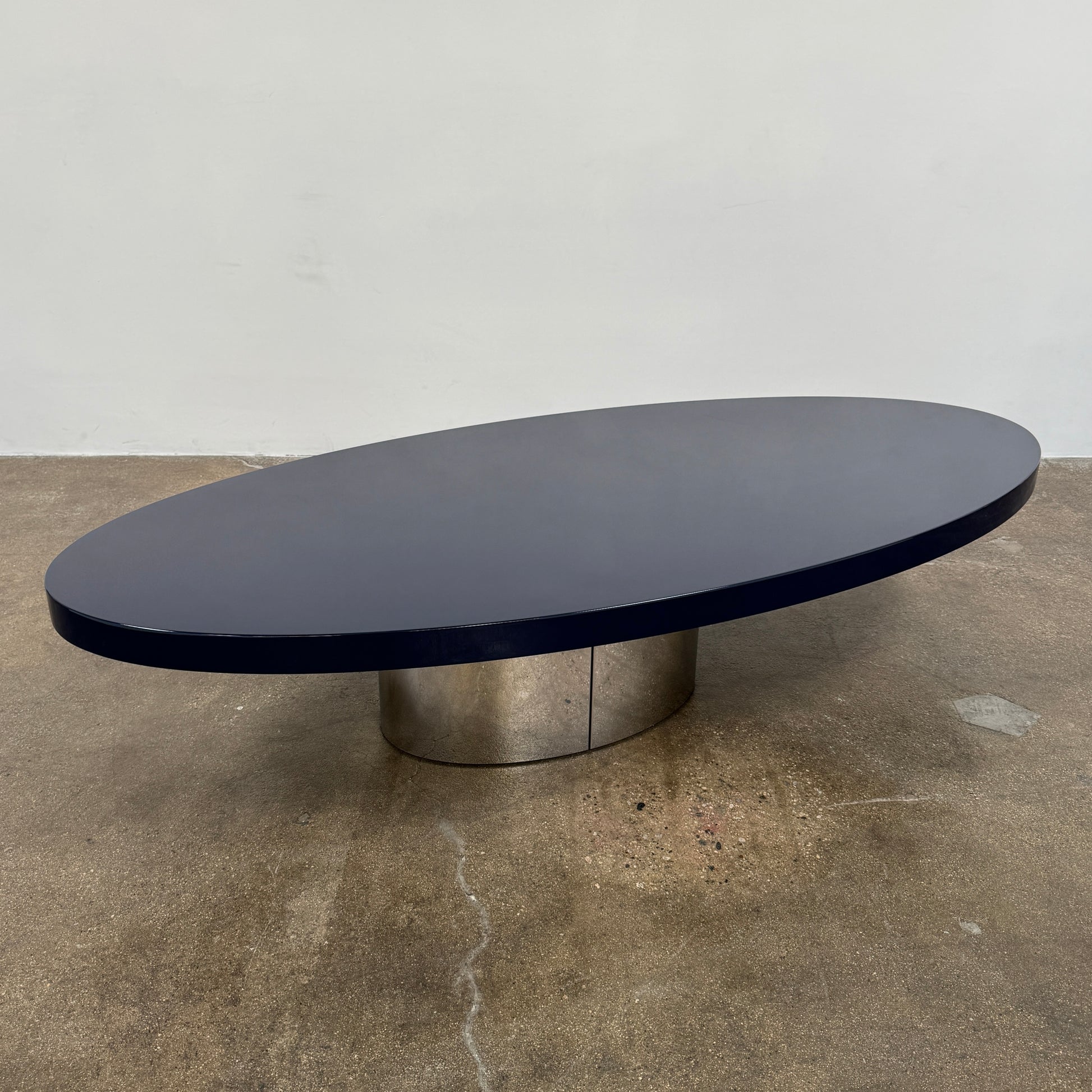 A sleek Minotti Raymond Coffee Table with a metal base, exhibiting clean shapes and proportions.