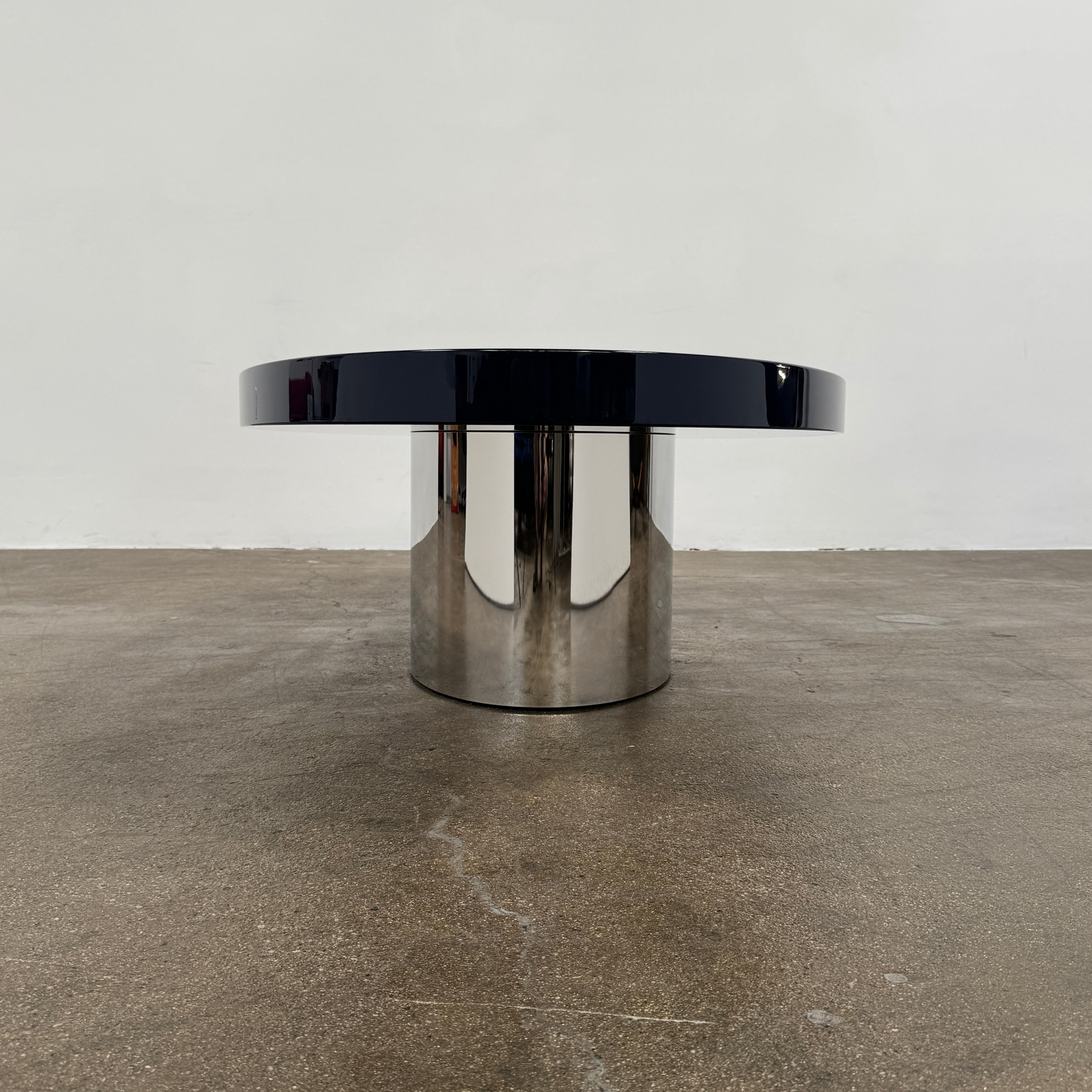 A sleek Minotti Raymond Coffee Table with a metal base, exhibiting clean shapes and proportions.