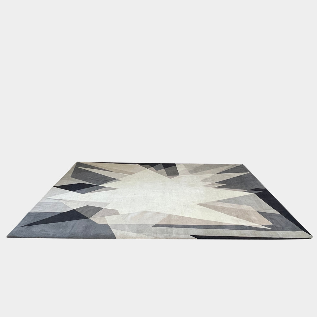 A dramatic black The Rug Company Alma Rug with geometric shapes on a white background.