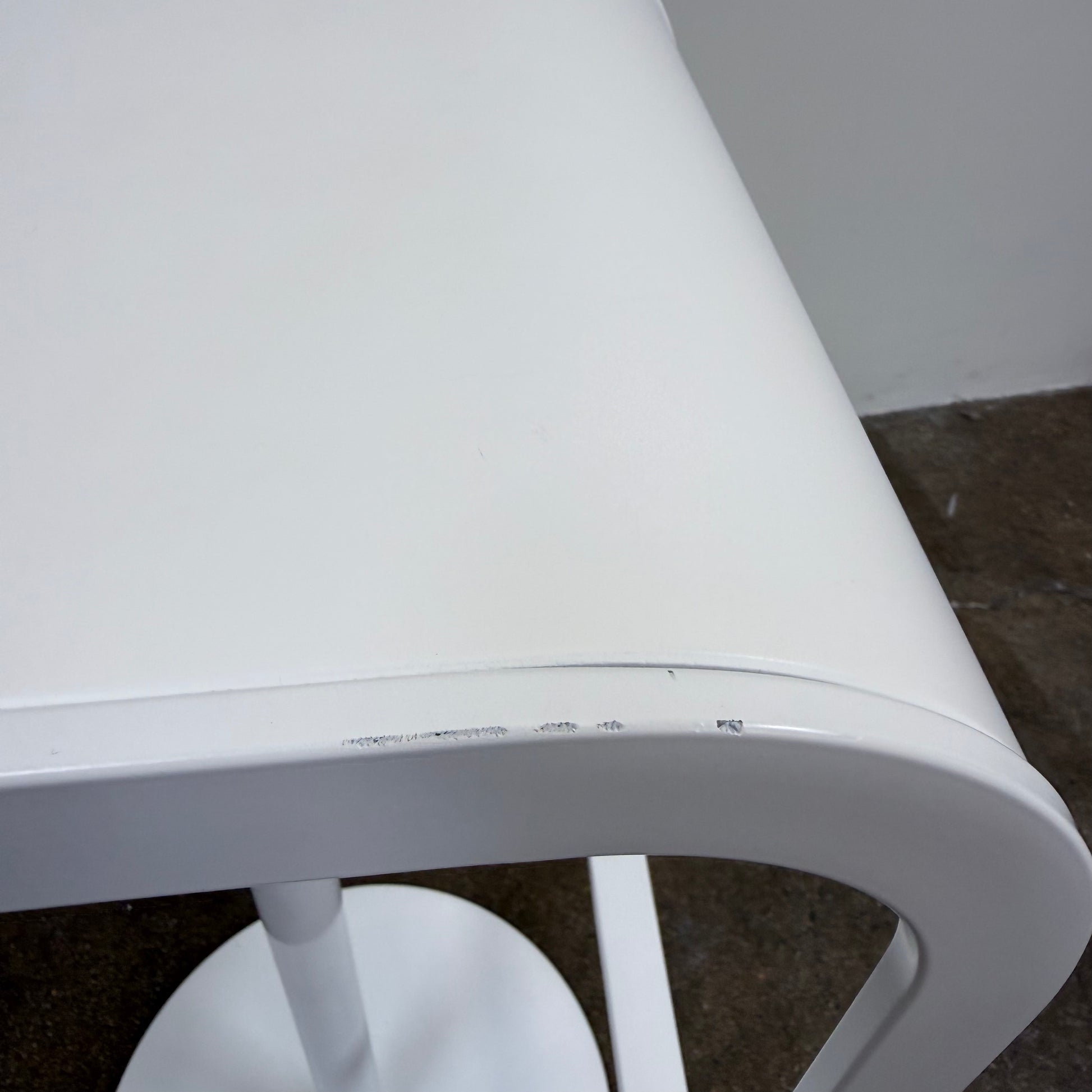 Two white LEM Piston Stools by La Palma featuring pedestal bases and rectangular footrests.