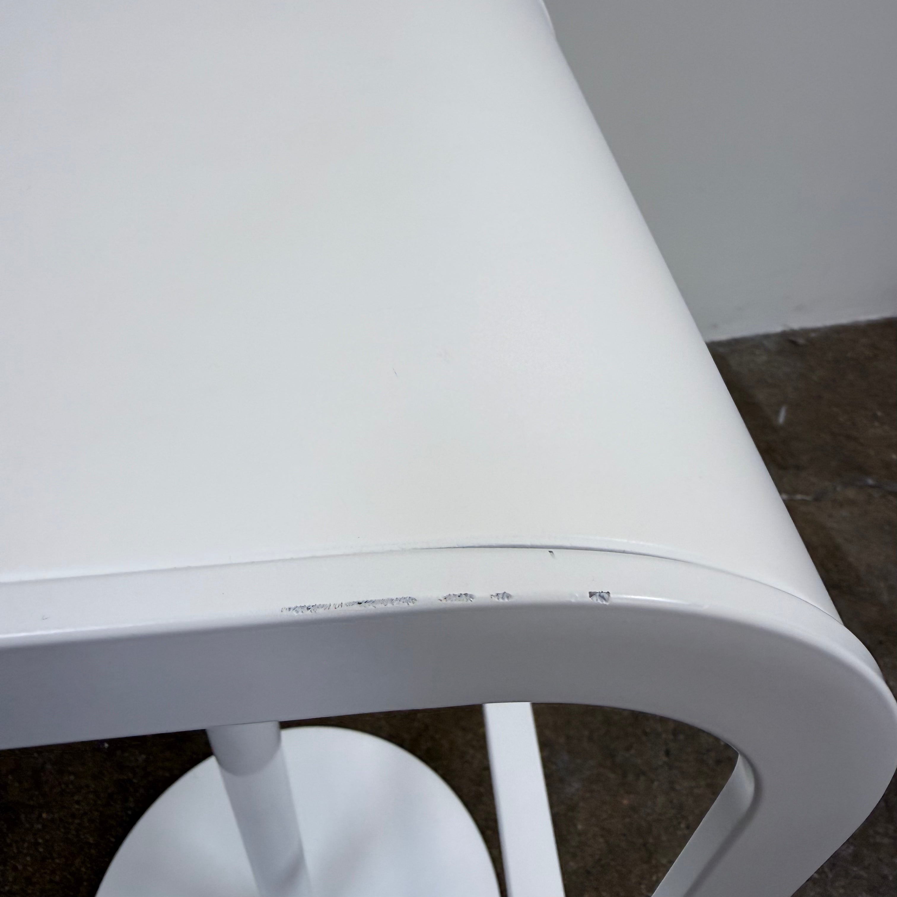 Two white LEM Piston Stools by La Palma featuring pedestal bases and rectangular footrests.