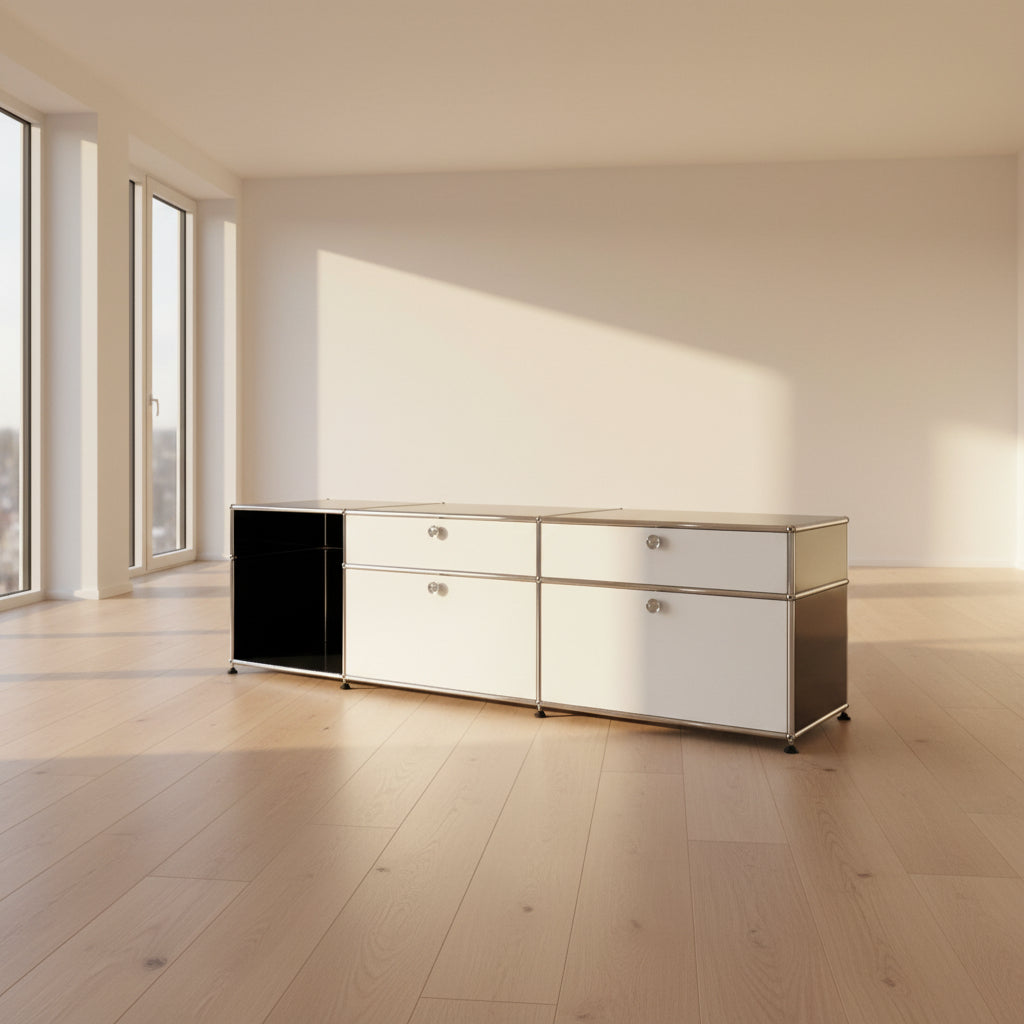 The USM Haller Cabinet / Console by Fritz Haller and Paul Schaerer for USM Haller features black and white panels, a metal frame, drawers, and open shelves—showcasing timeless modular design near a beige wall on concrete flooring.