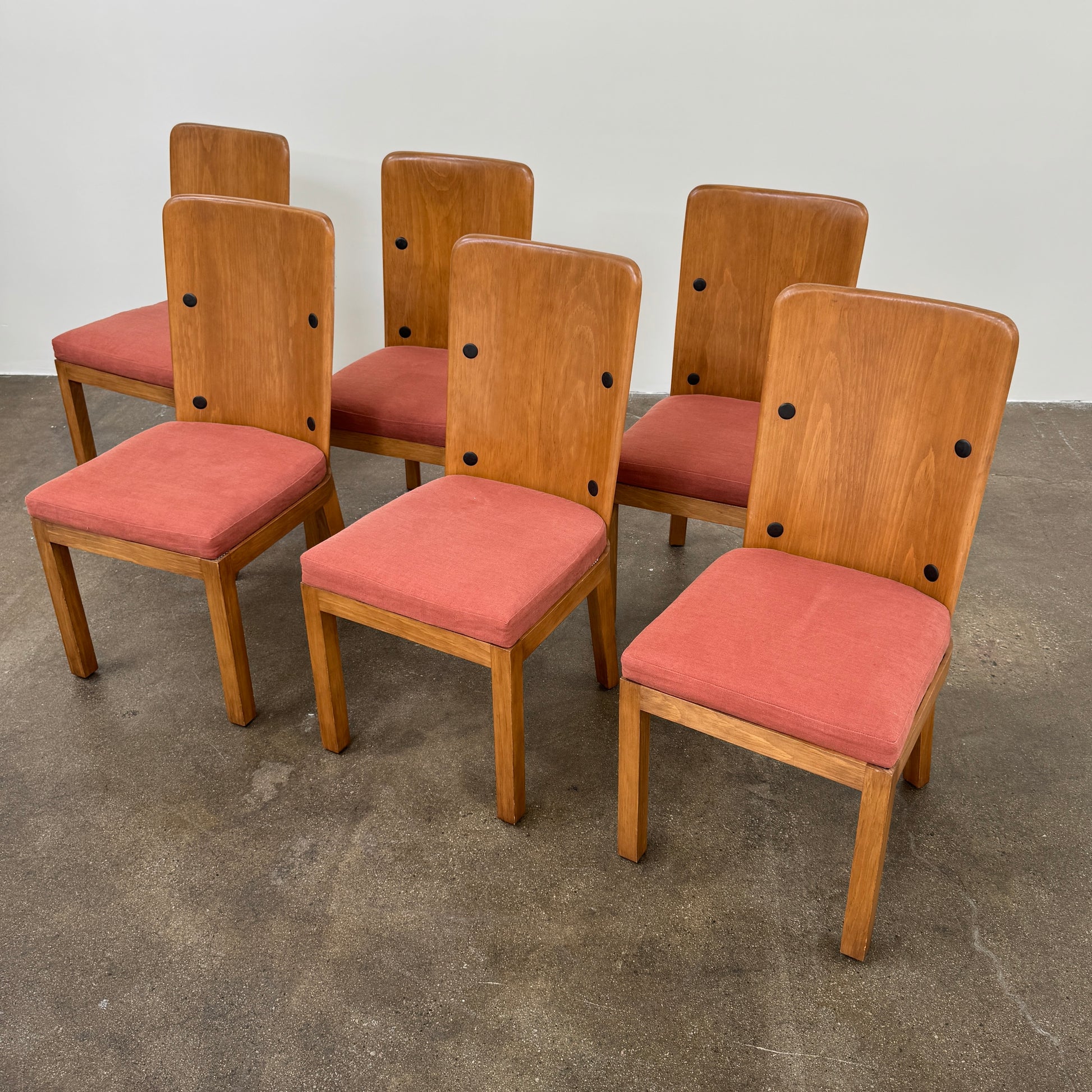 A set of six Waldo's Designs dining chairs in the style of Axel Enar Lovo, featuring rectangular backs and coral upholstery, are neatly arranged in two rows against a plain white background.