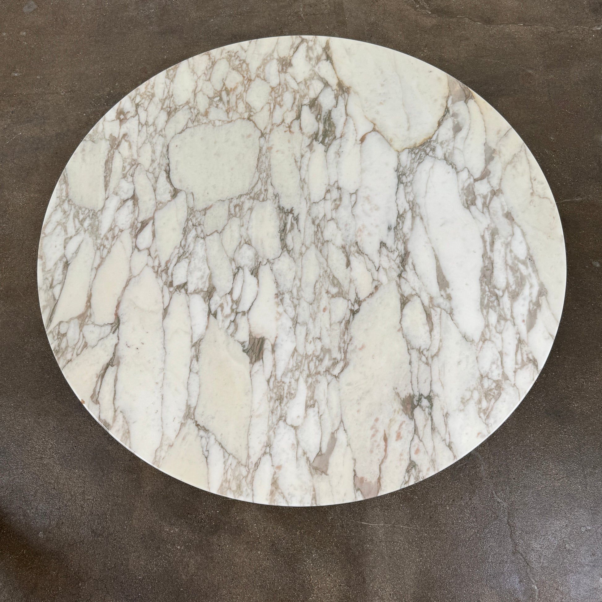 The Knoll Saarinen Table 54" Round Arabescato Marble features a white base and pedestal stand, inspired by the original Knoll design and shown isolated on a white background.