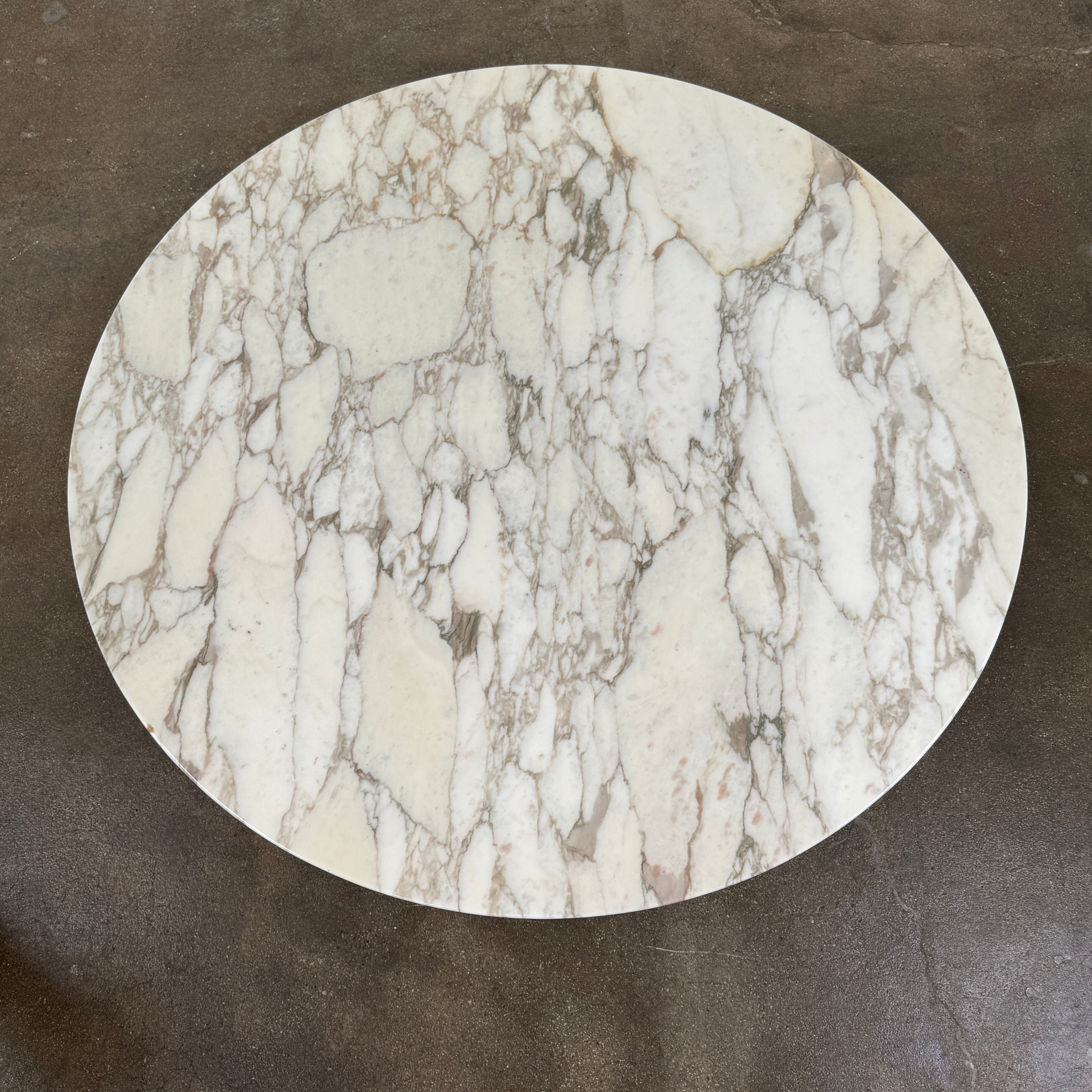 The Knoll Saarinen Table 54" Round Arabescato Marble features a white base and pedestal stand, inspired by the original Knoll design and shown isolated on a white background.