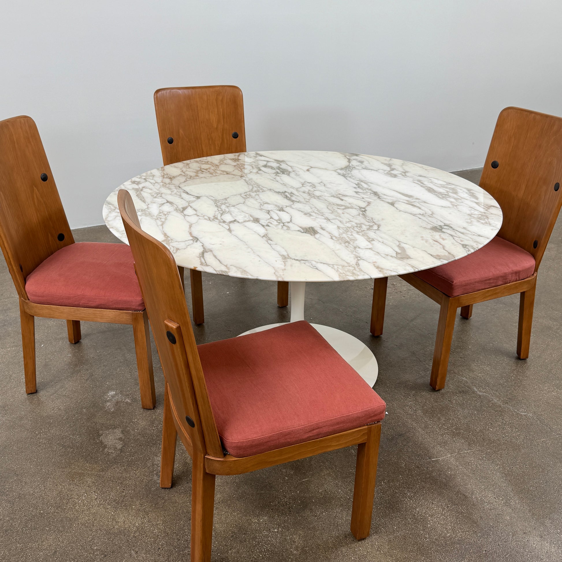The Knoll Saarinen Table 54" Round Arabescato Marble features a white base and pedestal stand, inspired by the original Knoll design and shown isolated on a white background.