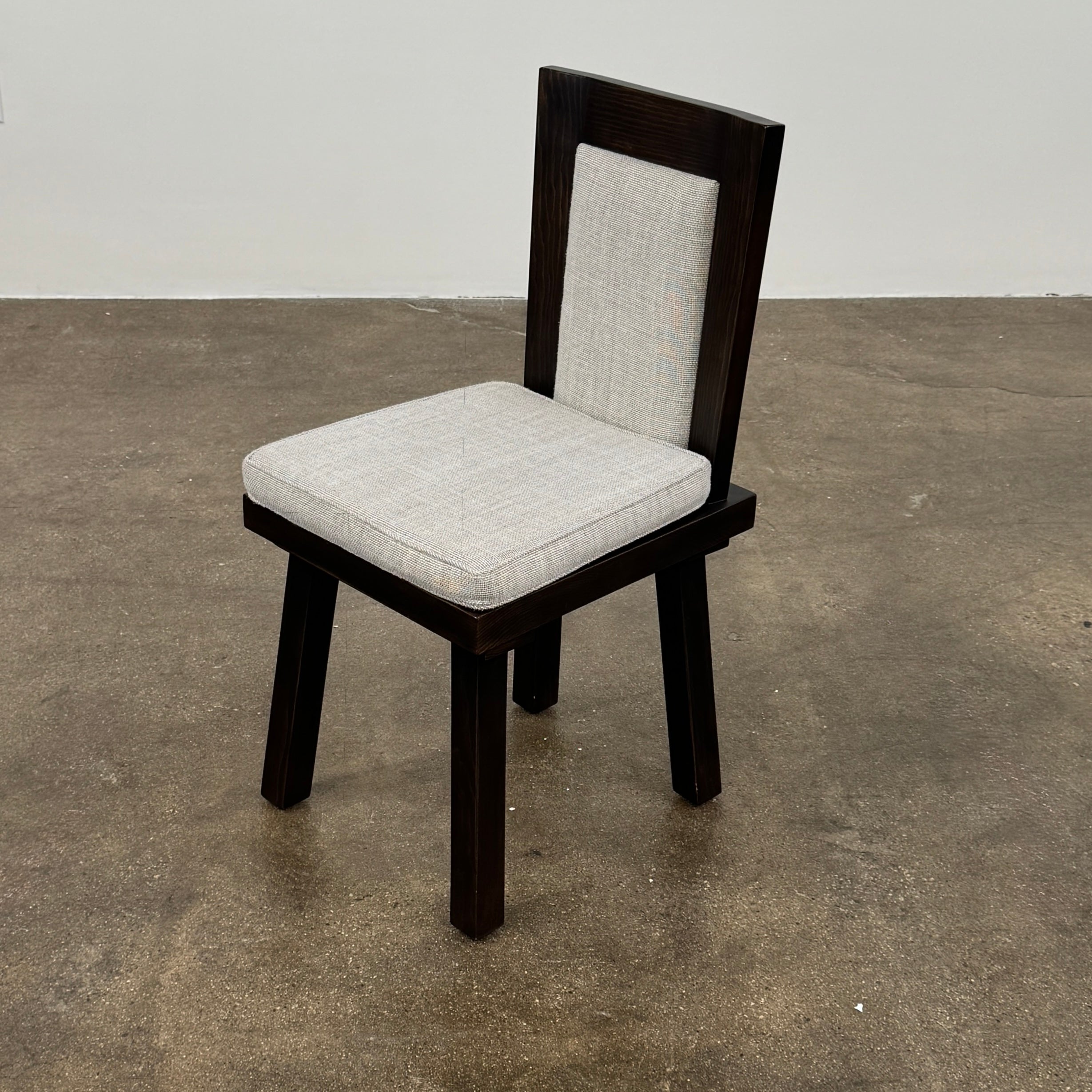 Six Waldo's Designs Custom Pine Dining Chairs (Set of 6) with light upholstered seats and backs are arranged in two rows on a bare concrete floor against a plain white wall.