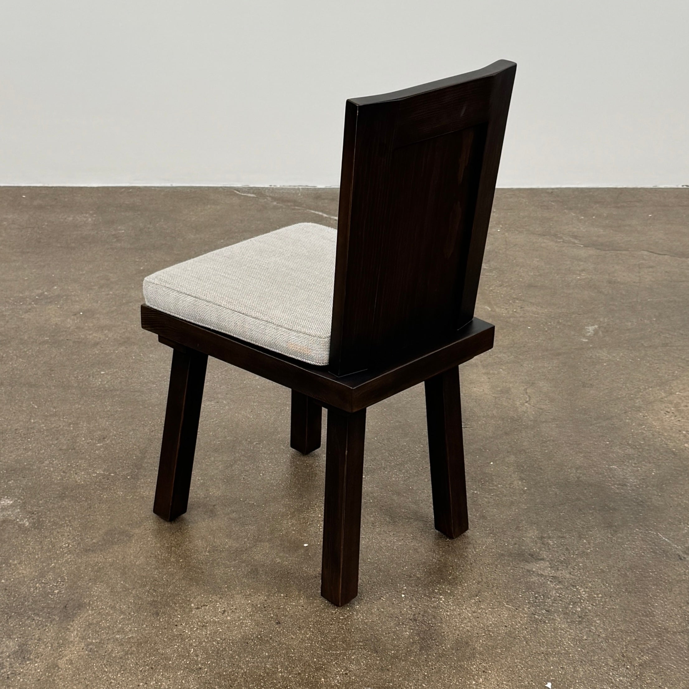 Six Waldo's Designs Custom Pine Dining Chairs (Set of 6) with light upholstered seats and backs are arranged in two rows on a bare concrete floor against a plain white wall.