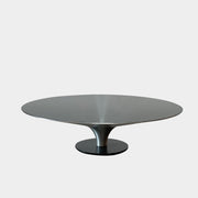 Three metallic, round tables of varying heights with flared pedestal bases echo the modern elegance of the Roche Bobois Ovni Cocktail Table by Roche Bobois—ideal as a statement centerpiece or a versatile coffee table set.