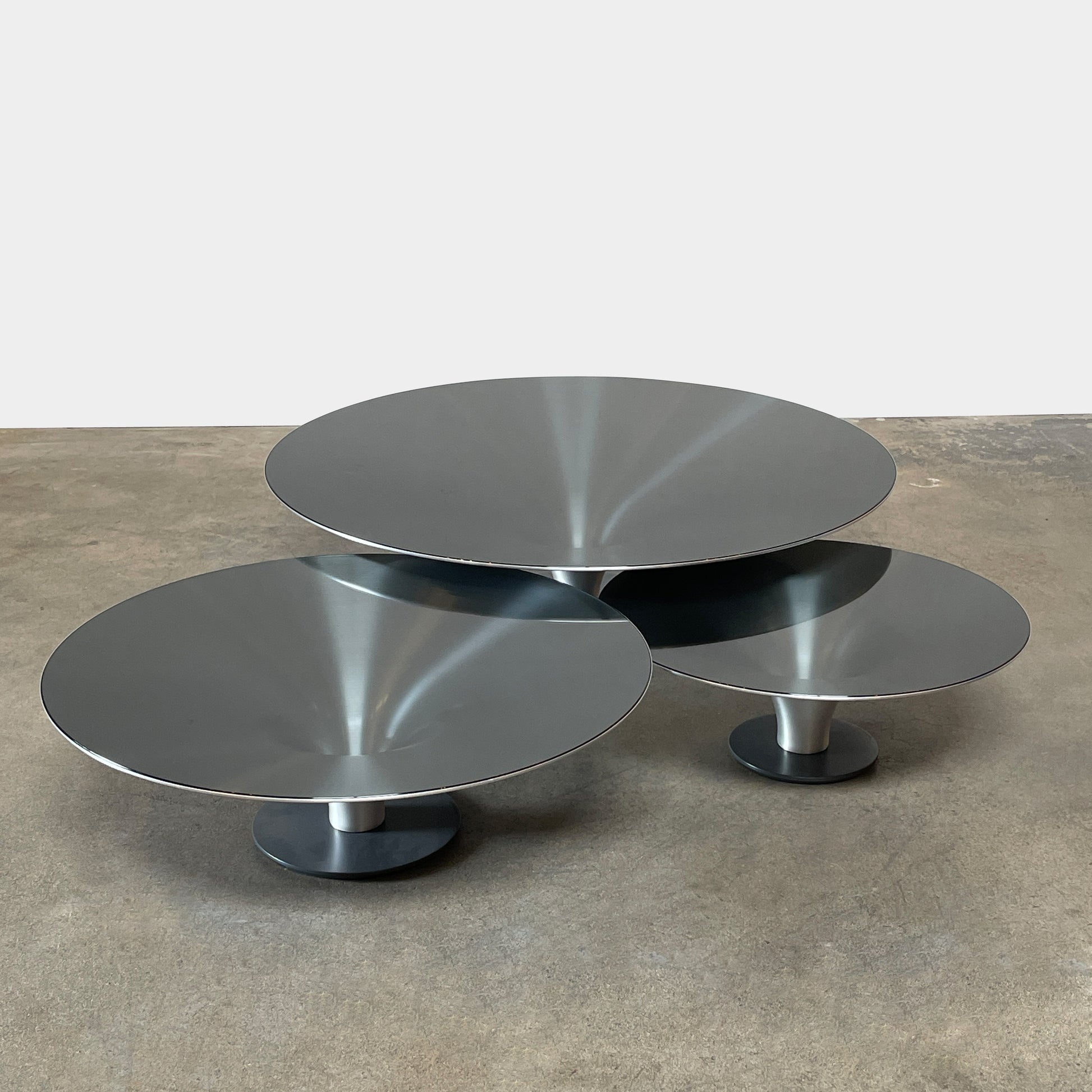 Three Roche Bobois Ovni Cocktail Tables of different sizes with reflective surfaces, isolated on a white background.