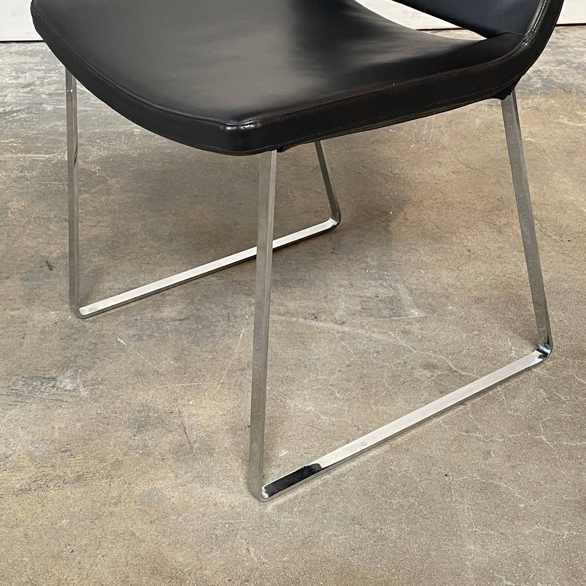 Five black B&B Italia Metropolitan dining chairs designed by Jeffrey Bernett, arranged in a row on a white background.