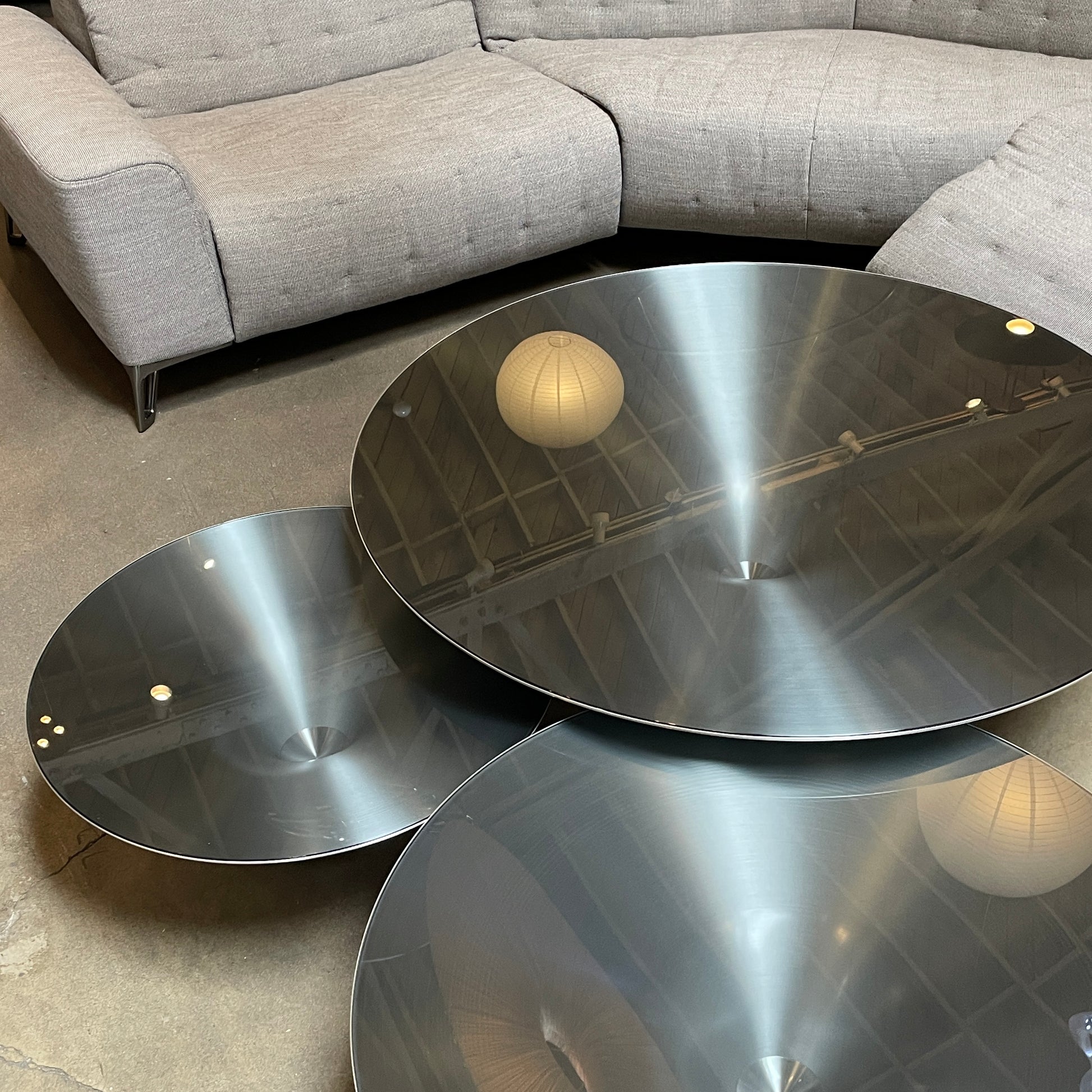 Three Roche Bobois Ovni Cocktail Tables of different sizes with reflective surfaces, isolated on a white background.