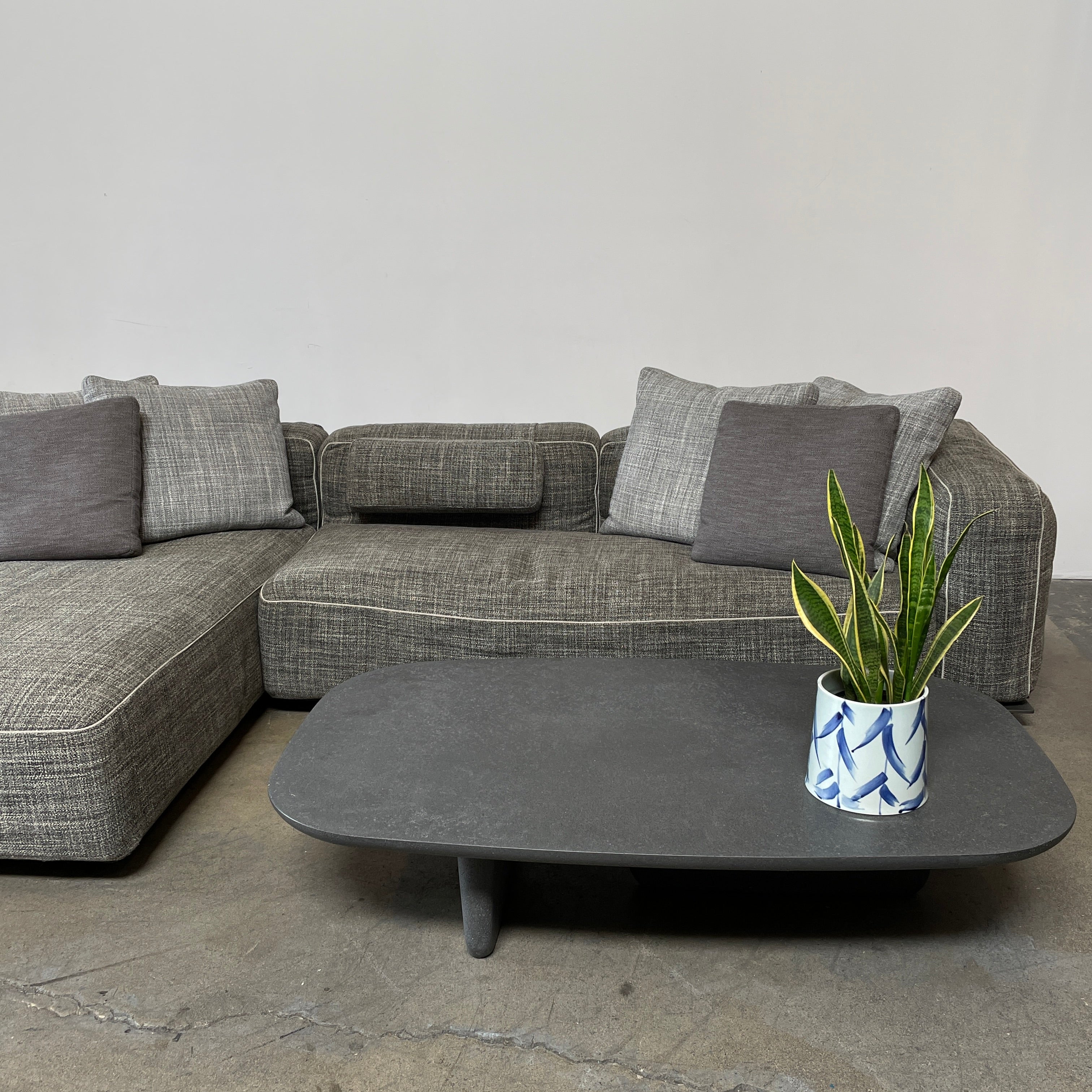 A rectangular black coffee table with asymmetrical supports on a white background, reminiscent of the B&B Italia Tobi-Ishi Outdoor Coffee Table (hold) by B&B Italia.