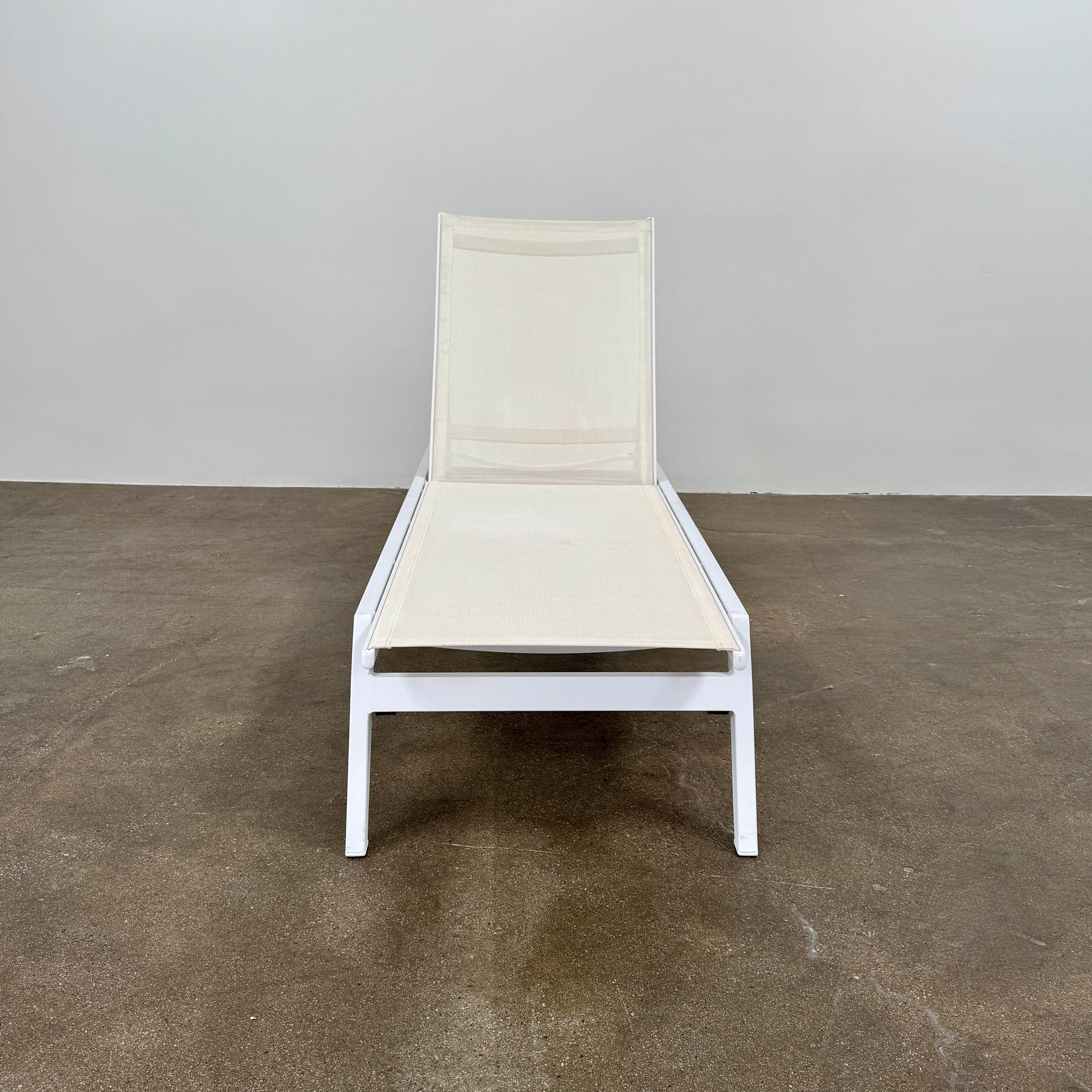 The Serge Ferrari Sun Lounger is a white, modern piece with an adjustable backrest, crafted from metal and mesh using durable Serge Ferrari fabric, shown on a plain white background.
