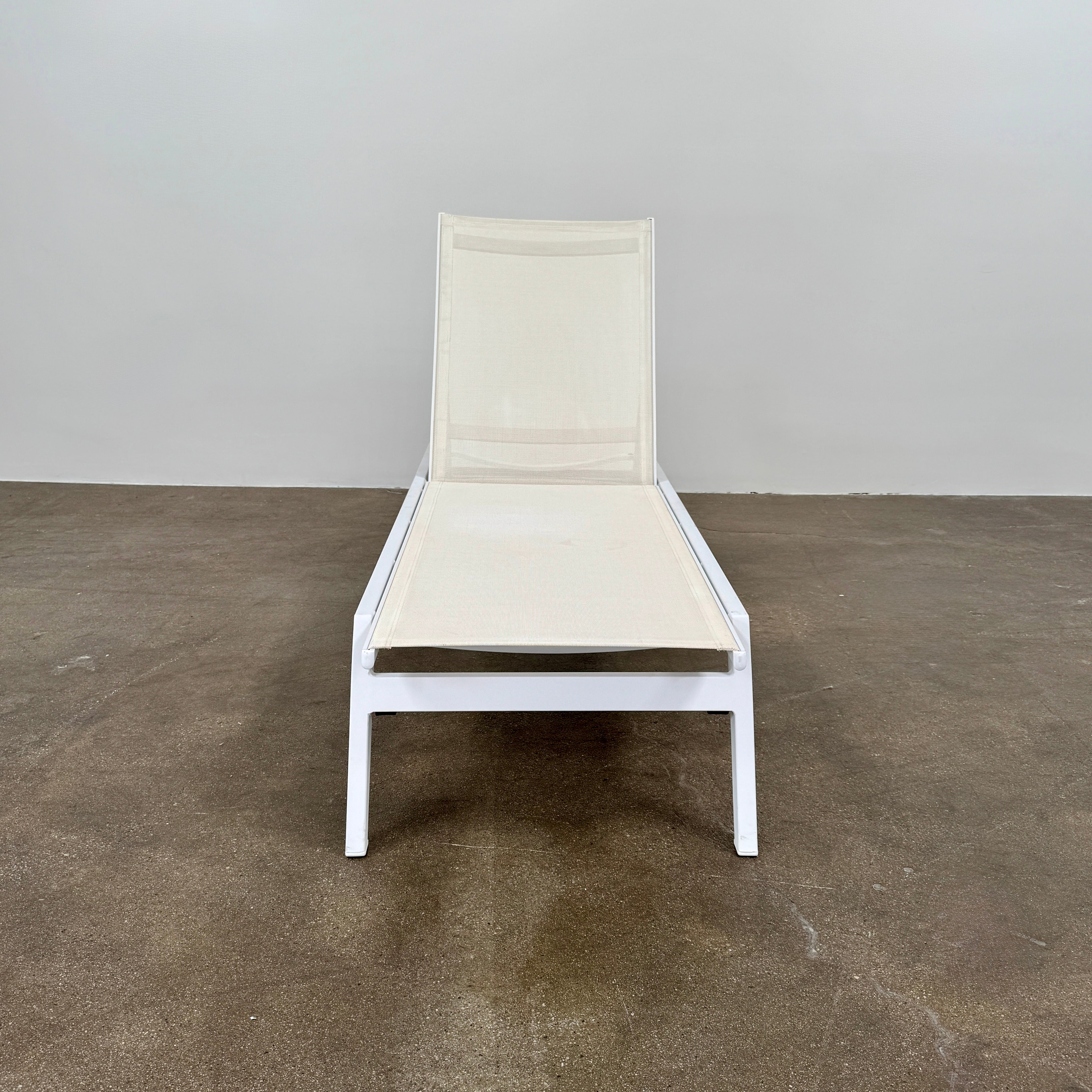 The Serge Ferrari Sun Lounger is a white, modern piece with an adjustable backrest, crafted from metal and mesh using durable Serge Ferrari fabric, shown on a plain white background.