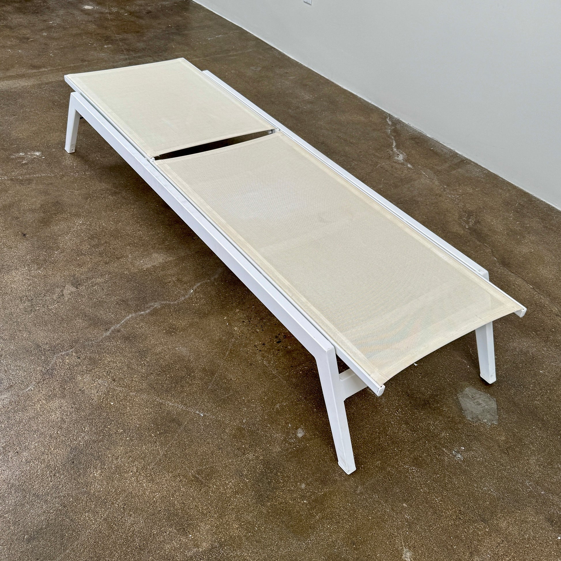 The Serge Ferrari Sun Lounger is a white, modern piece with an adjustable backrest, crafted from metal and mesh using durable Serge Ferrari fabric, shown on a plain white background.