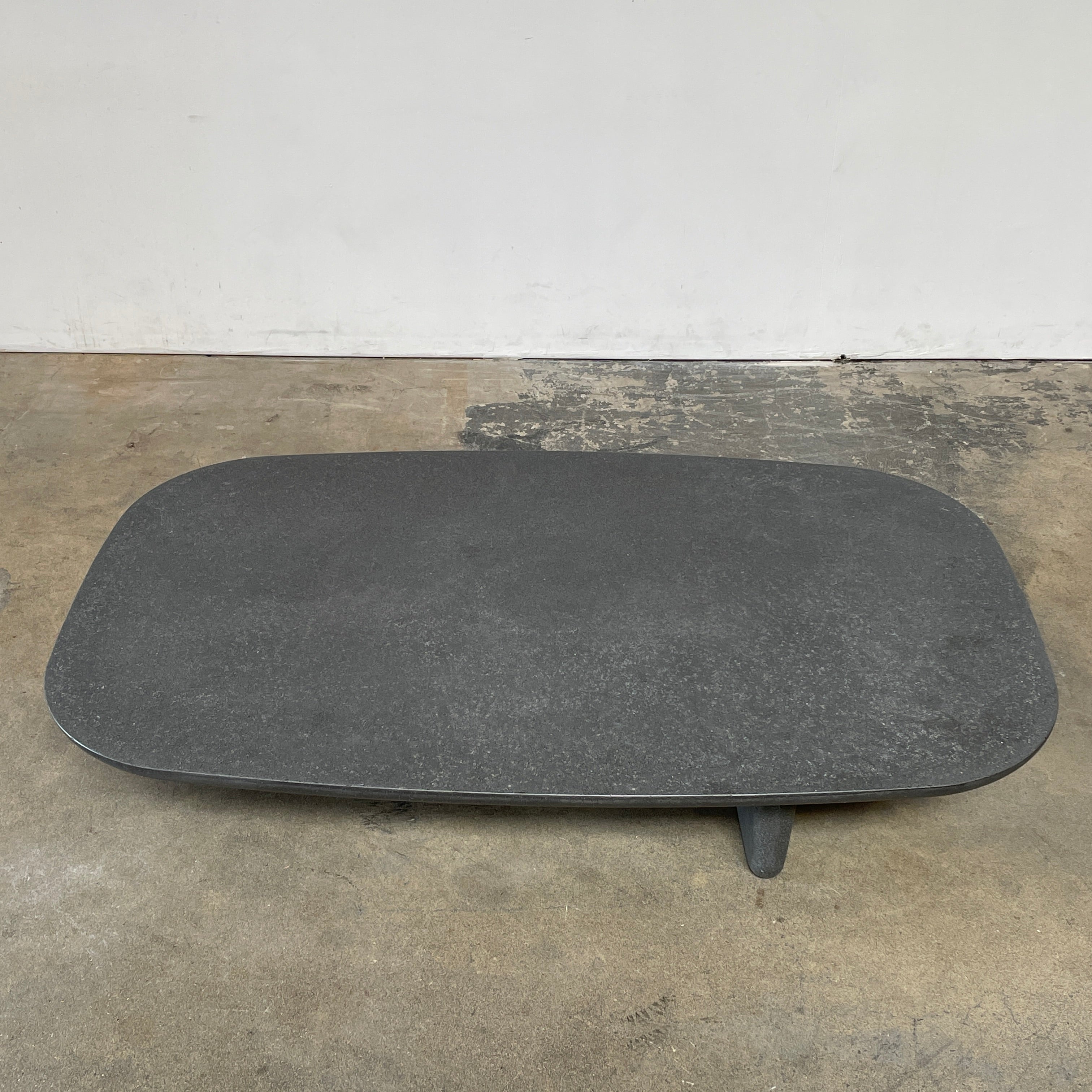 A rectangular black coffee table with asymmetrical supports on a white background, reminiscent of the B&B Italia Tobi-Ishi Outdoor Coffee Table (hold) by B&B Italia.