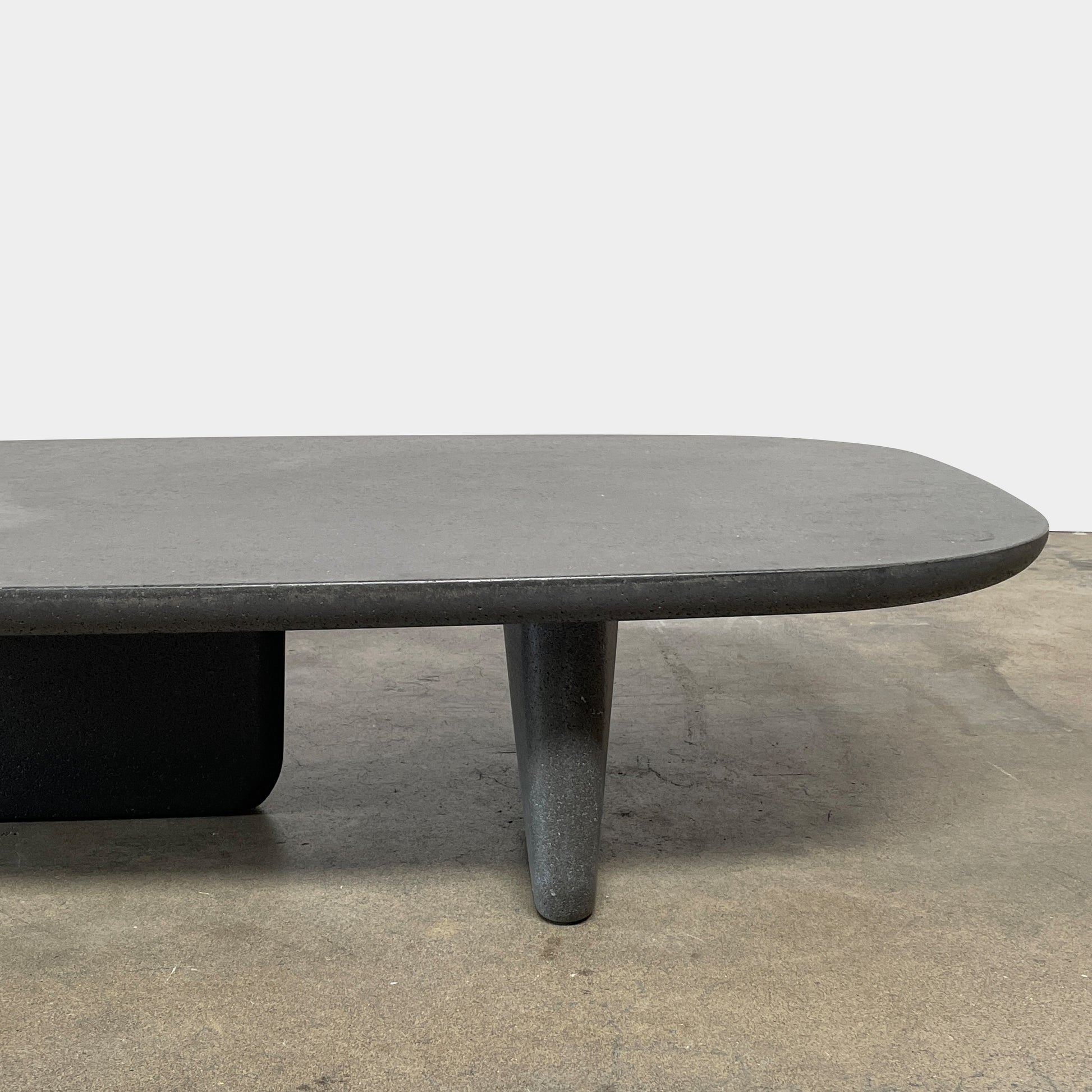 A rectangular black coffee table with asymmetrical supports on a white background, reminiscent of the B&B Italia Tobi-Ishi Outdoor Coffee Table (hold) by B&B Italia.