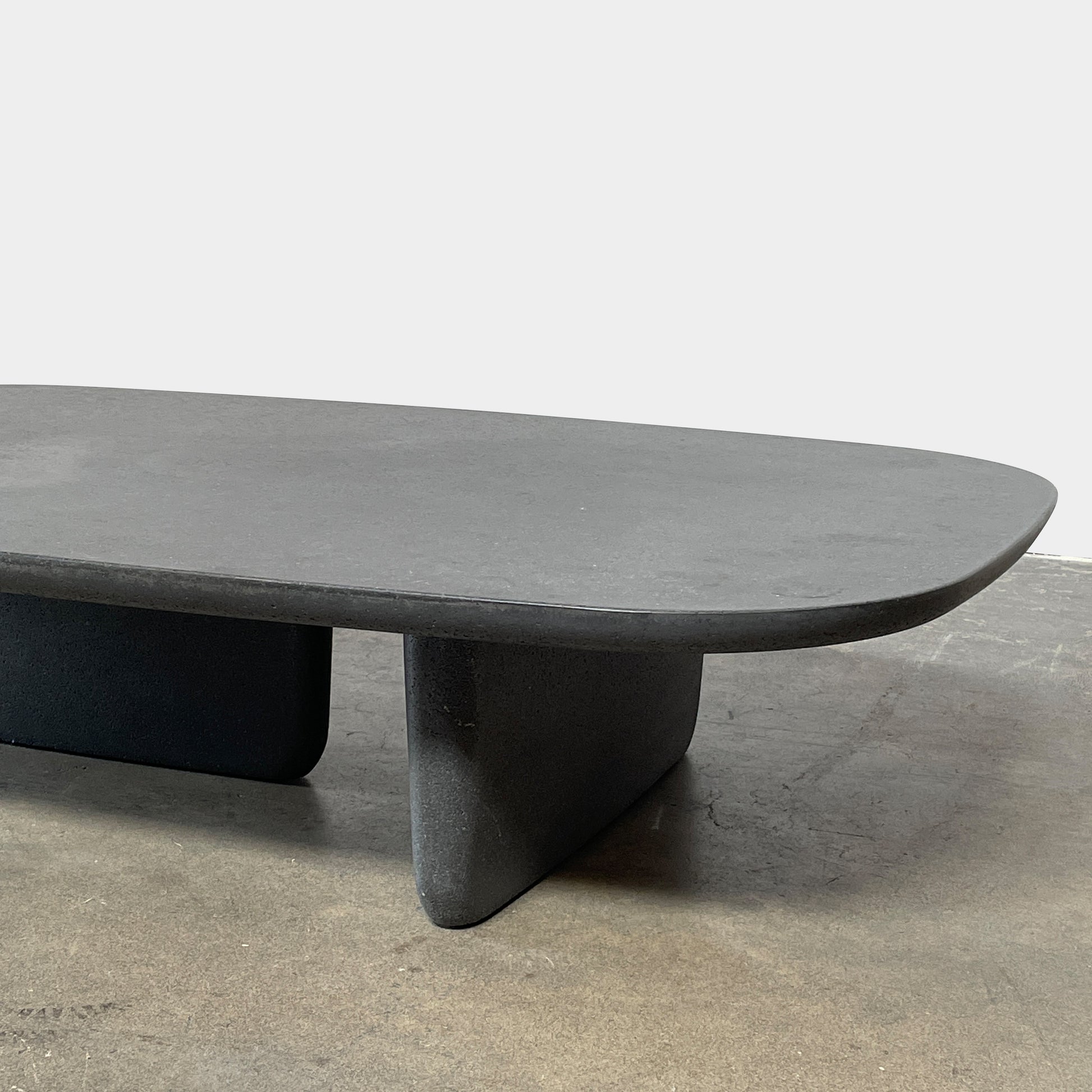 A rectangular black coffee table with asymmetrical supports on a white background, reminiscent of the B&B Italia Tobi-Ishi Outdoor Coffee Table (hold) by B&B Italia.