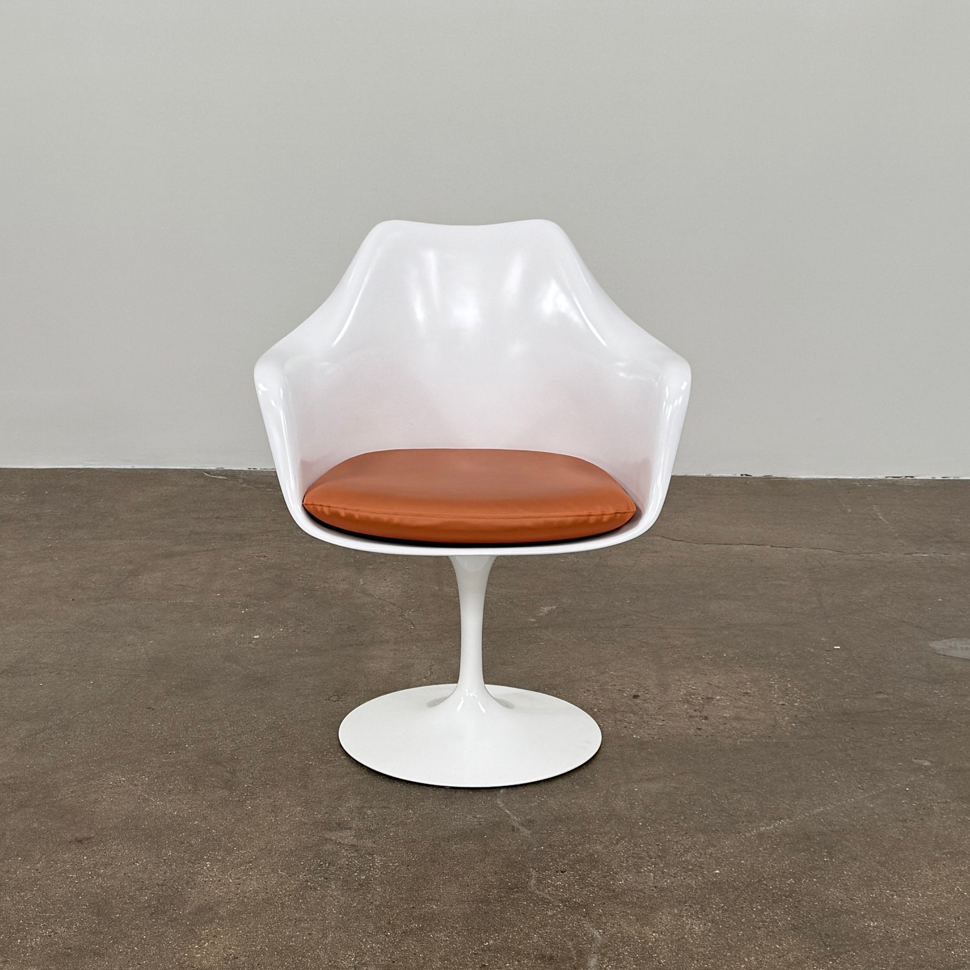 Four Knoll Saarinen Tulip Armchairs with brown vinyl seat cushions and pedestal bases, by Knoll, are arranged on a plain white background.