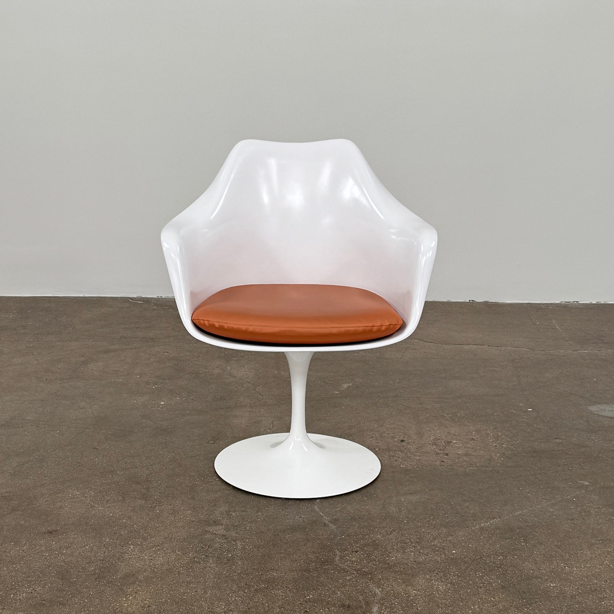 Four Knoll Saarinen Tulip Armchairs with brown vinyl seat cushions and pedestal bases, by Knoll, are arranged on a plain white background.