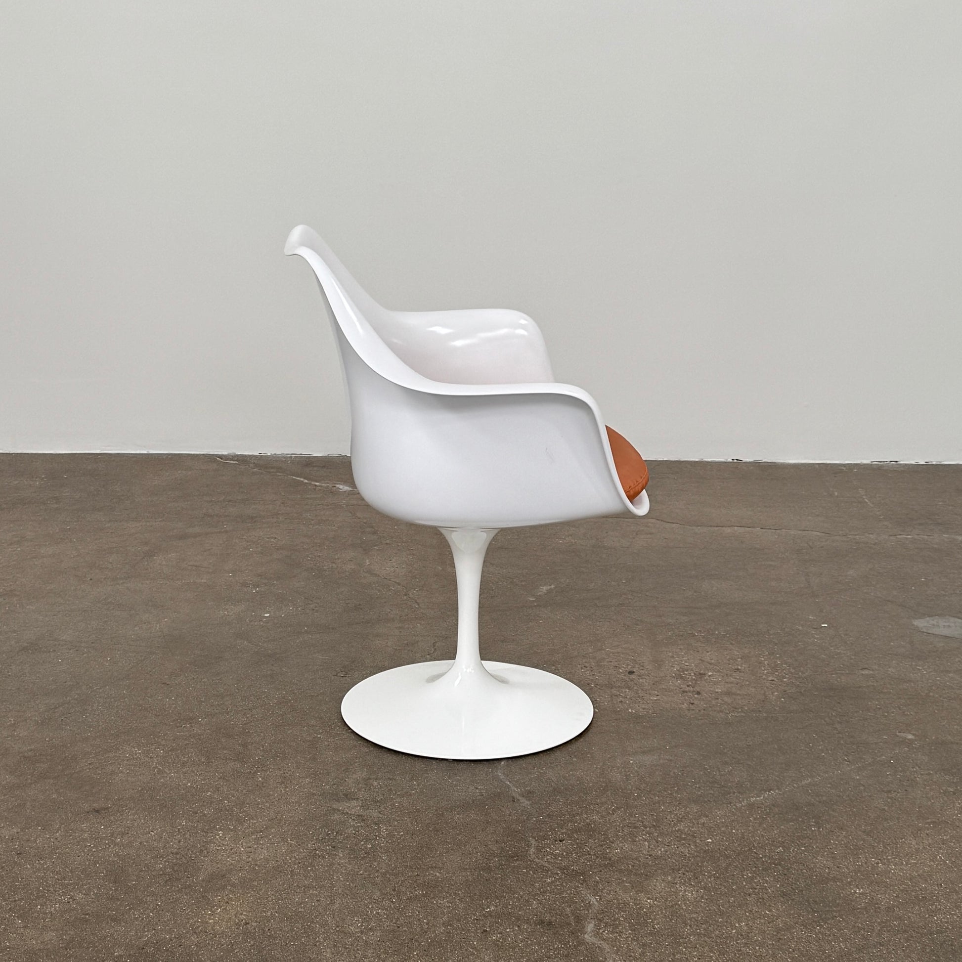 Four Knoll Saarinen Tulip Armchairs with brown vinyl seat cushions and pedestal bases, by Knoll, are arranged on a plain white background.