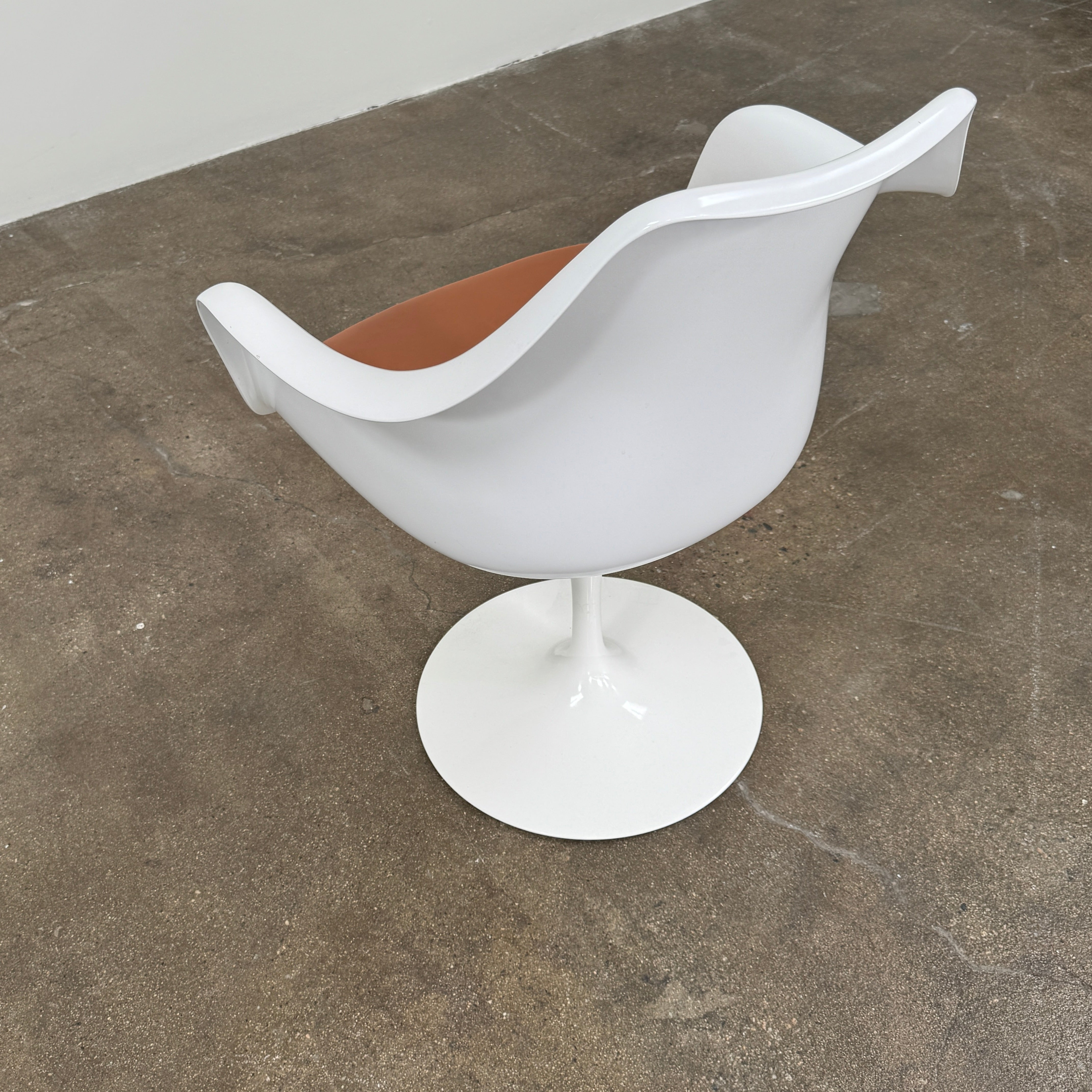 Four Knoll Saarinen Tulip Armchairs with brown vinyl seat cushions and pedestal bases, by Knoll, are arranged on a plain white background.