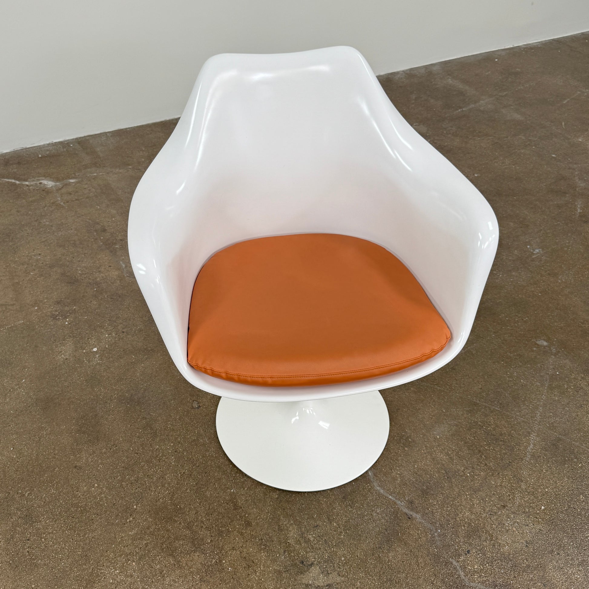 Four Knoll Saarinen Tulip Armchairs with brown vinyl seat cushions and pedestal bases, by Knoll, are arranged on a plain white background.
