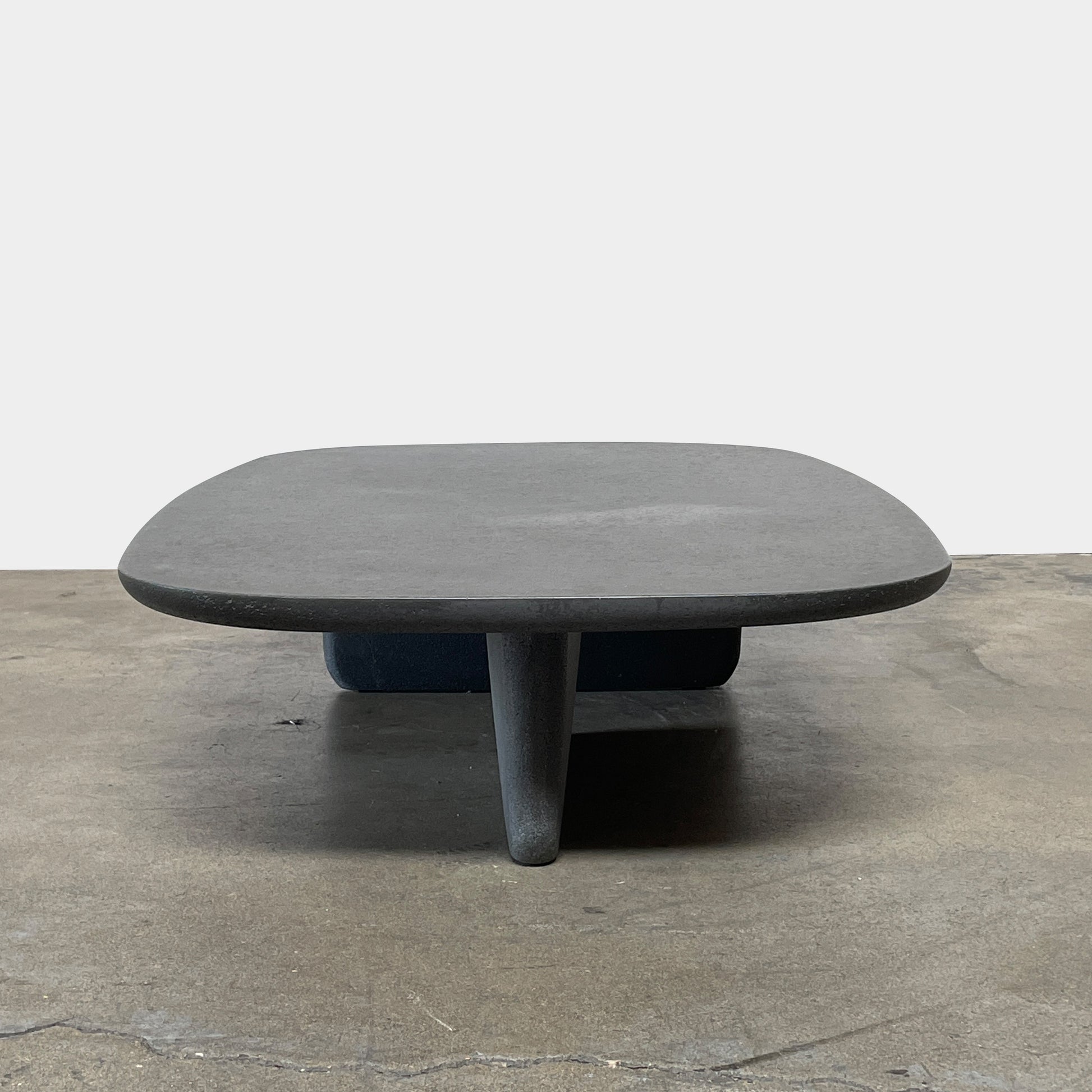 A rectangular black coffee table with asymmetrical supports on a white background, reminiscent of the B&B Italia Tobi-Ishi Outdoor Coffee Table (hold) by B&B Italia.