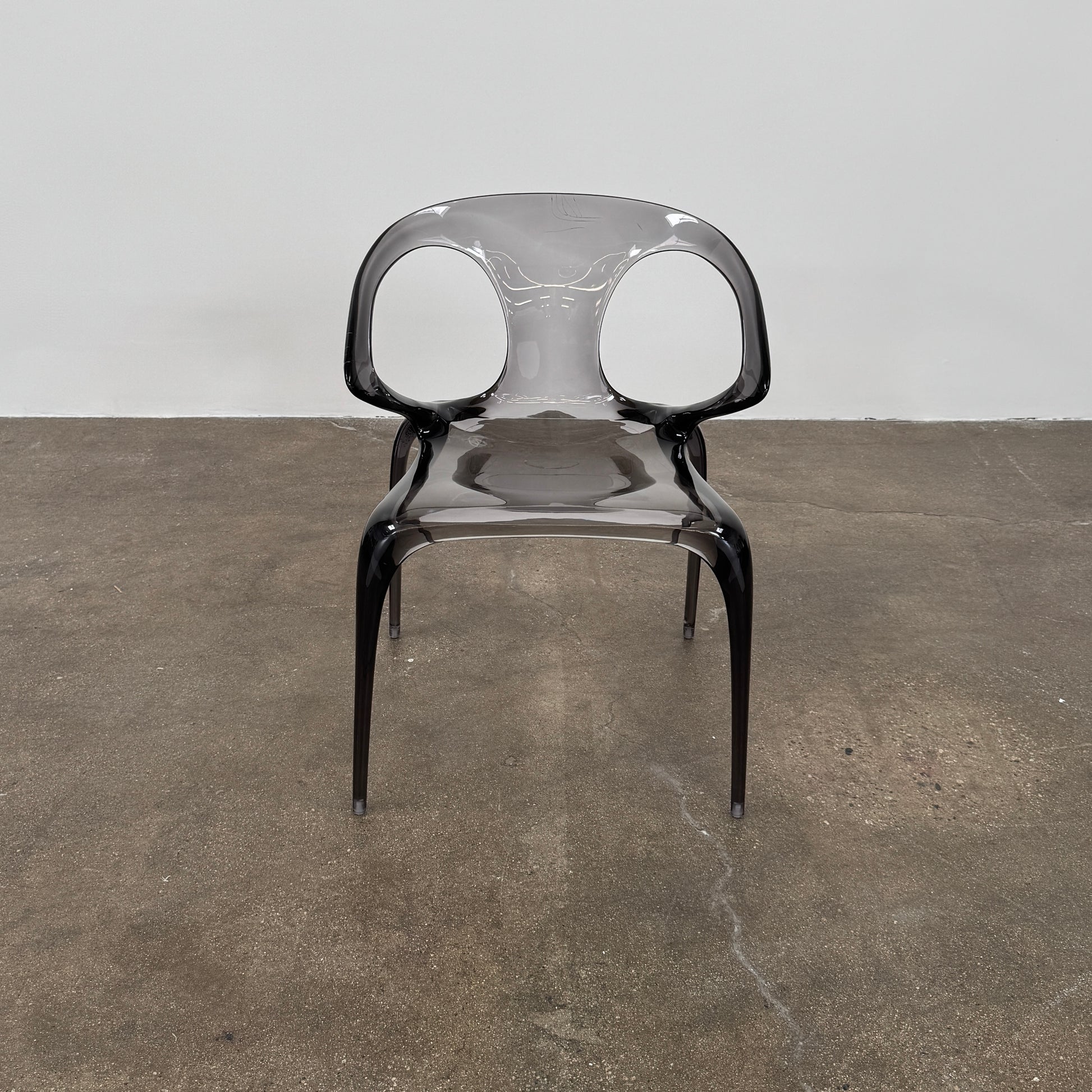 Four stackable Roche Bobois Ava Transparent Chairs (Set of 4) with rounded backs and armrests are arranged in two rows against a plain white background, showcasing the sleek modern style of Roche Bobois.