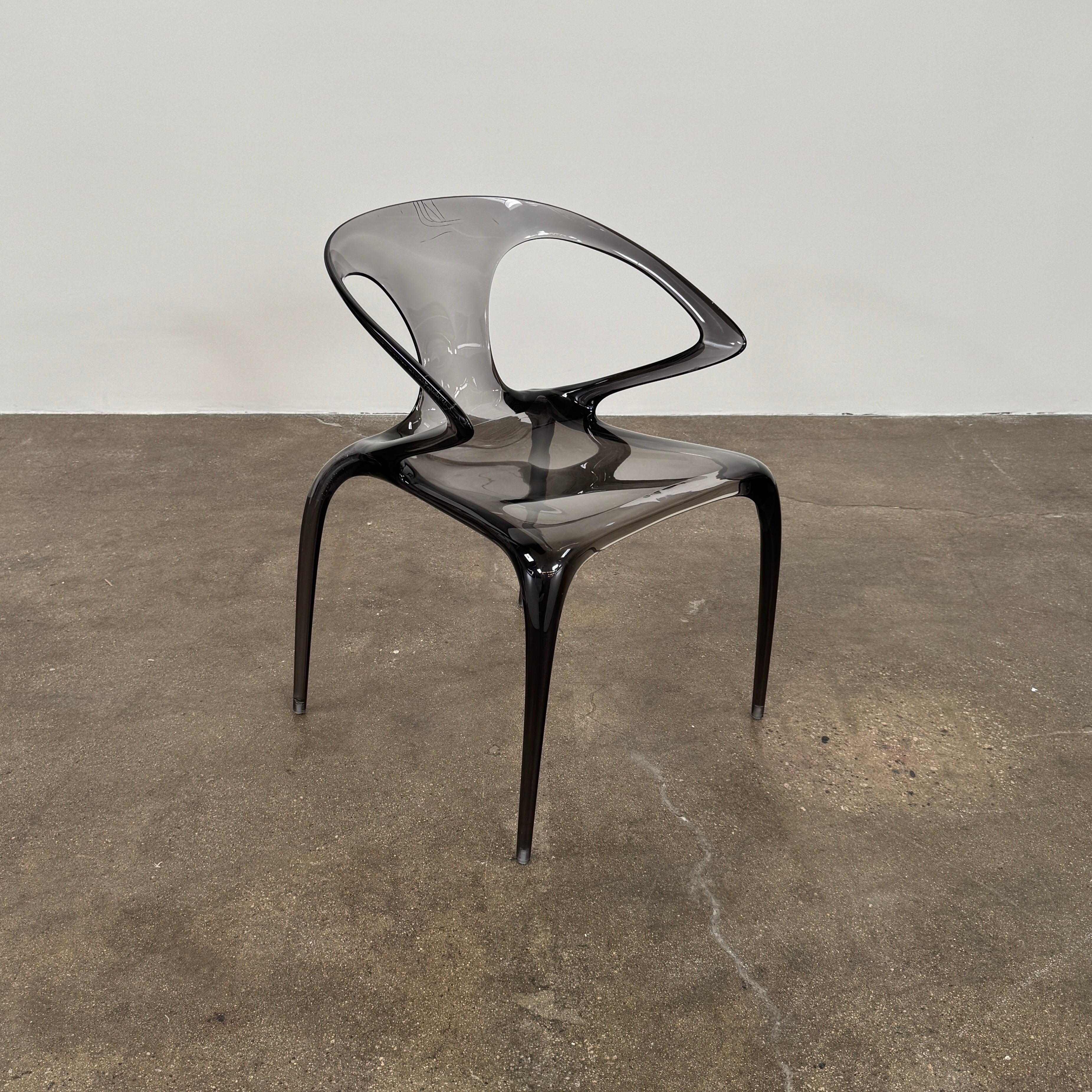 Four stackable Roche Bobois Ava Transparent Chairs (Set of 4) with rounded backs and armrests are arranged in two rows against a plain white background, showcasing the sleek modern style of Roche Bobois.