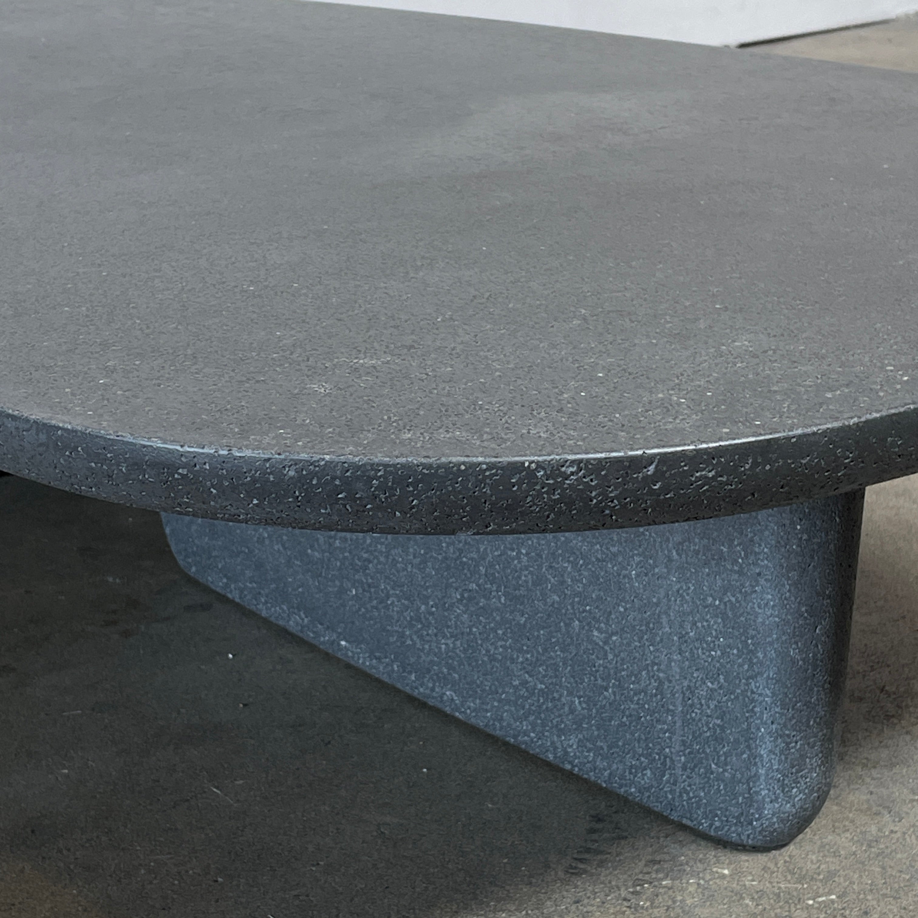 A rectangular black coffee table with asymmetrical supports on a white background, reminiscent of the B&B Italia Tobi-Ishi Outdoor Coffee Table (hold) by B&B Italia.