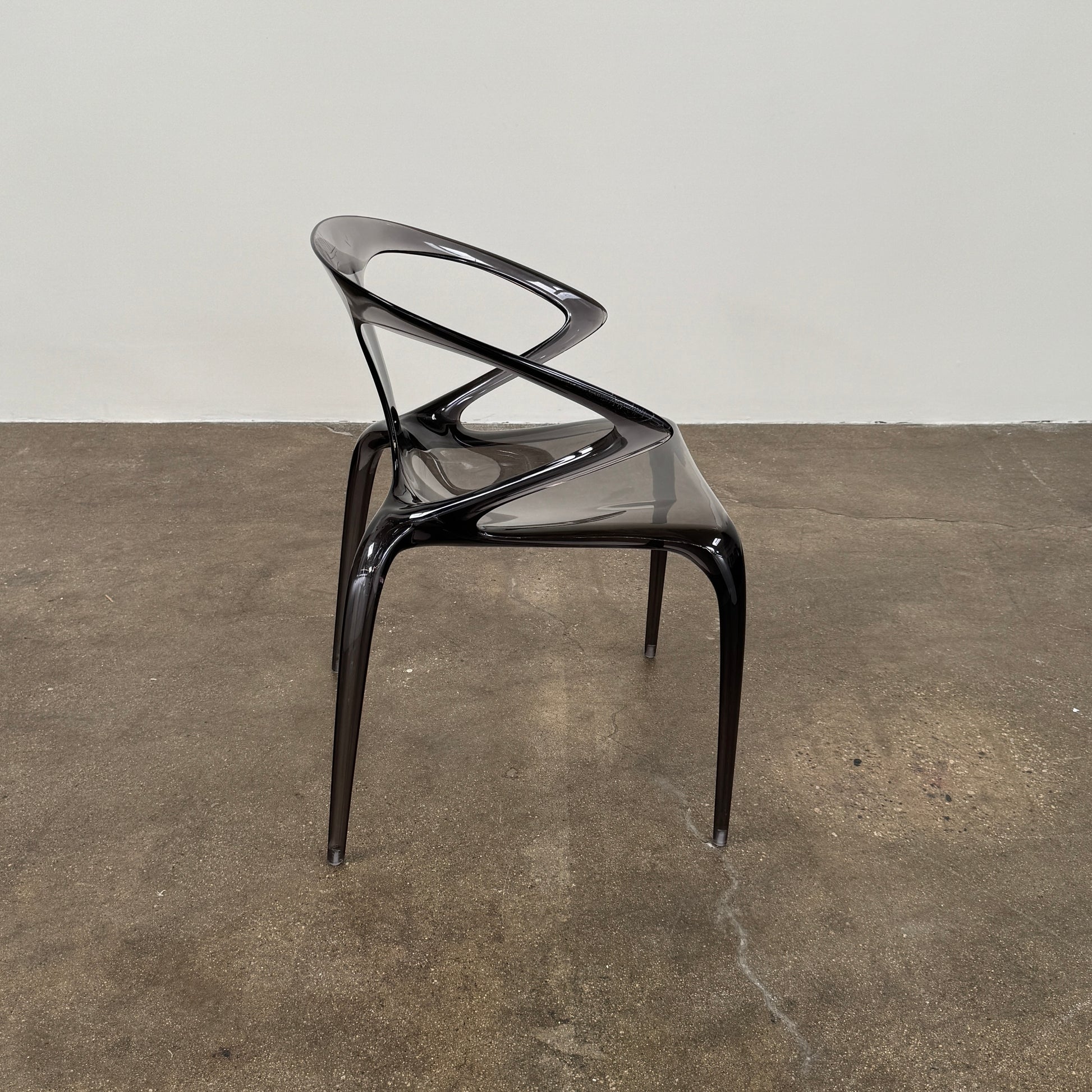 Four stackable Roche Bobois Ava Transparent Chairs (Set of 4) with rounded backs and armrests are arranged in two rows against a plain white background, showcasing the sleek modern style of Roche Bobois.