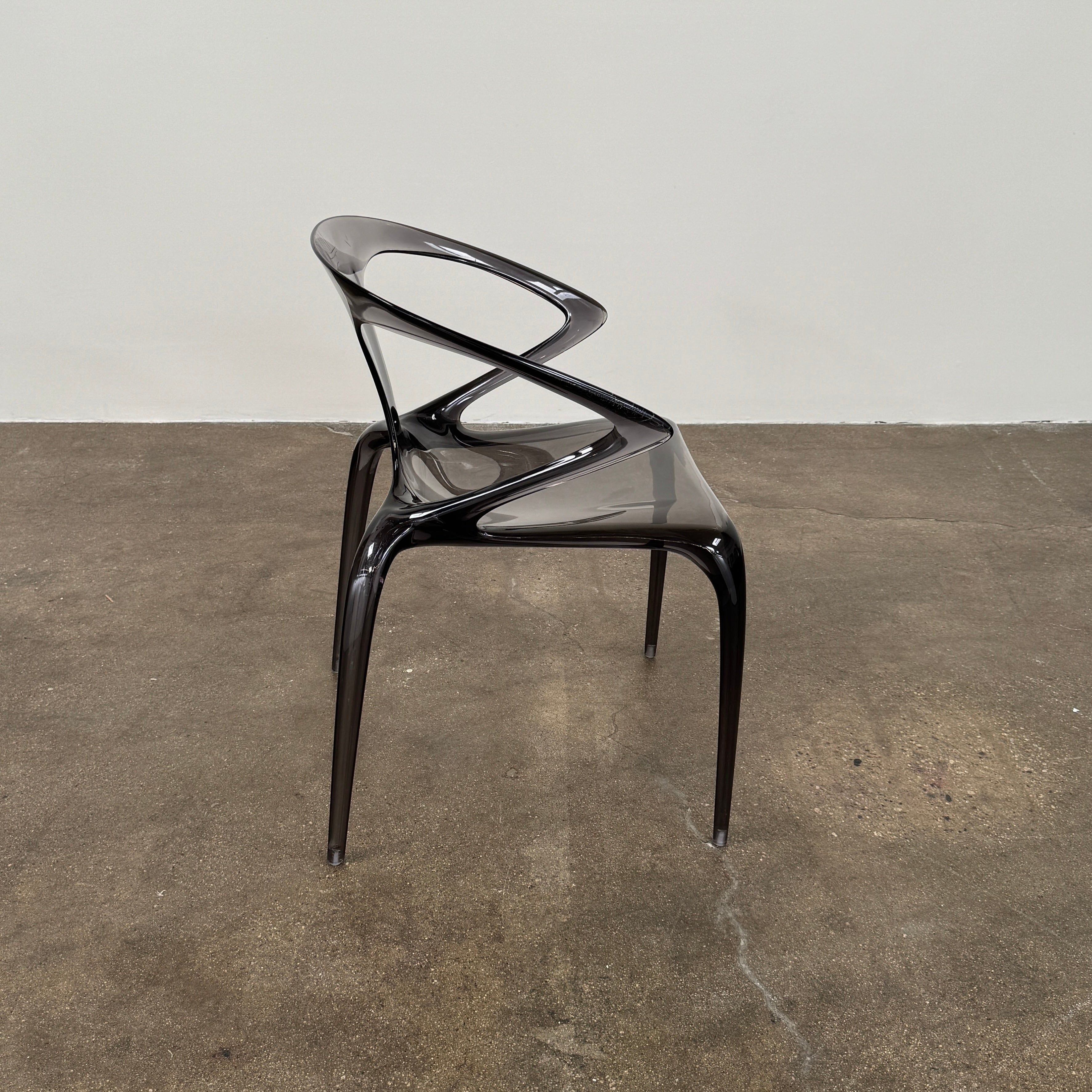 Four stackable Roche Bobois Ava Transparent Chairs (Set of 4) with rounded backs and armrests are arranged in two rows against a plain white background, showcasing the sleek modern style of Roche Bobois.