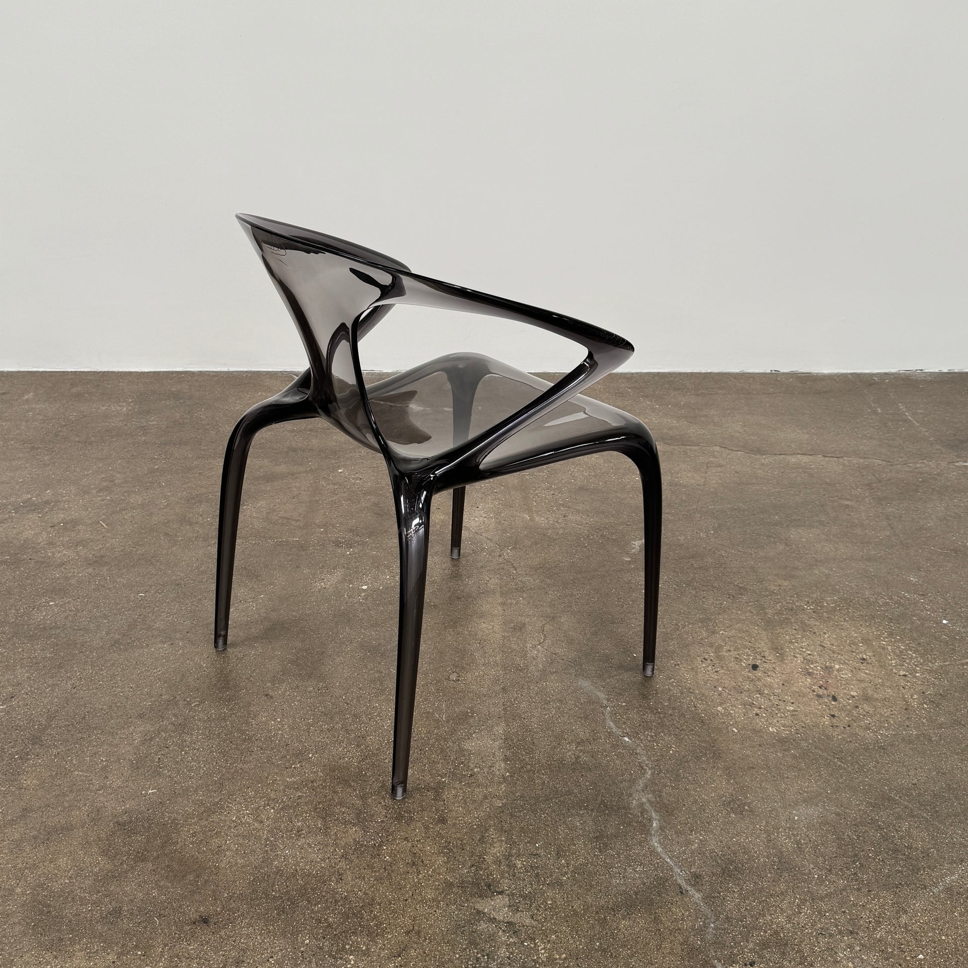 Four stackable Roche Bobois Ava Transparent Chairs (Set of 4) with rounded backs and armrests are arranged in two rows against a plain white background, showcasing the sleek modern style of Roche Bobois.