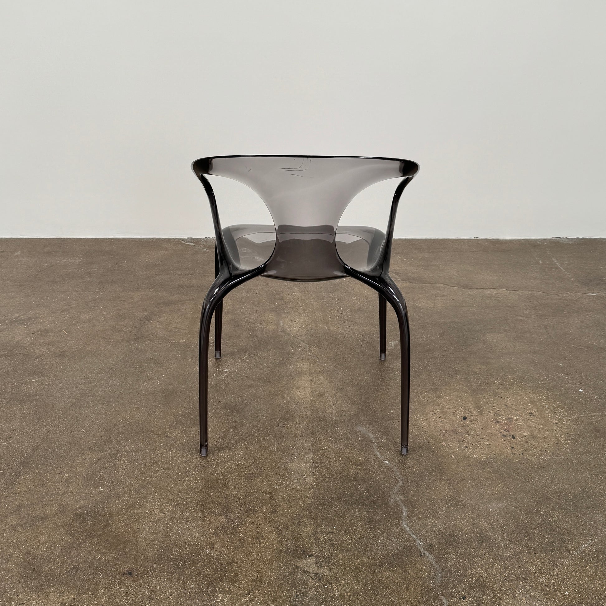 Four stackable Roche Bobois Ava Transparent Chairs (Set of 4) with rounded backs and armrests are arranged in two rows against a plain white background, showcasing the sleek modern style of Roche Bobois.