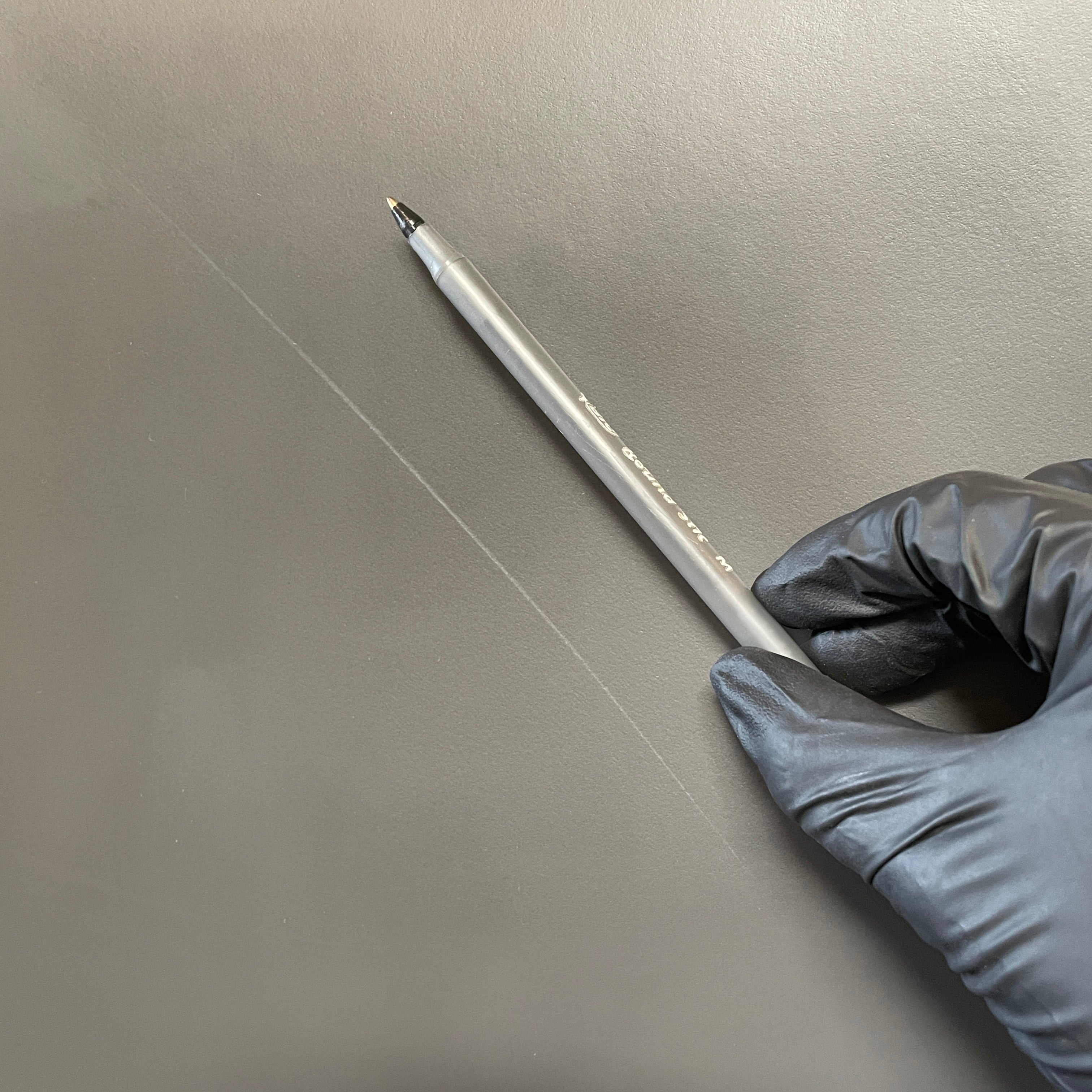 Four Frag Bella Dining Chairs in Dark Grey Leather with metal legs, arranged in a straight line against a plain white background.