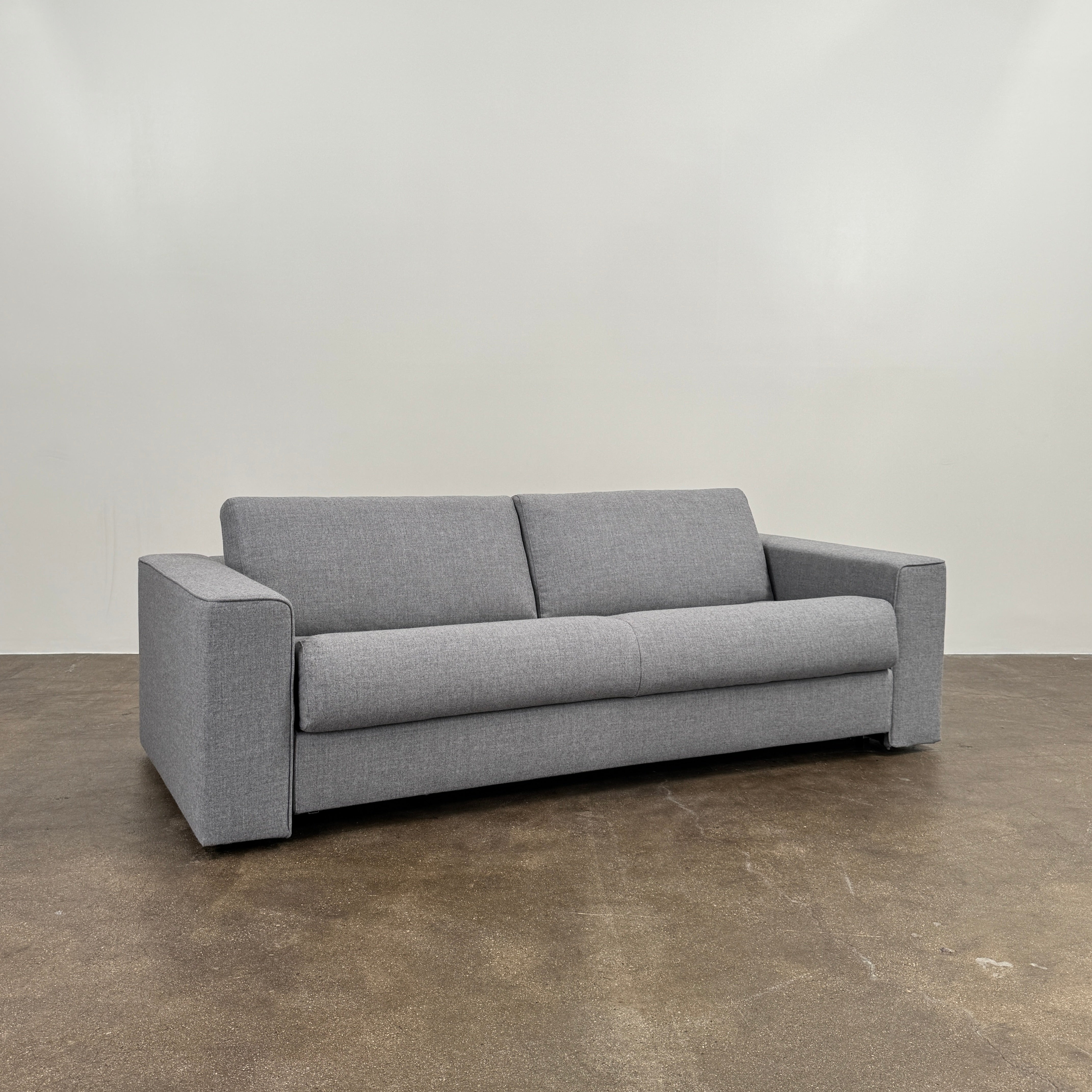 The Ligne Roset Do Not Disturb Sleeper Sofa by Ligne Roset is a modern gray two-seater with straight armrests and minimalist design, pictured against a plain white background.