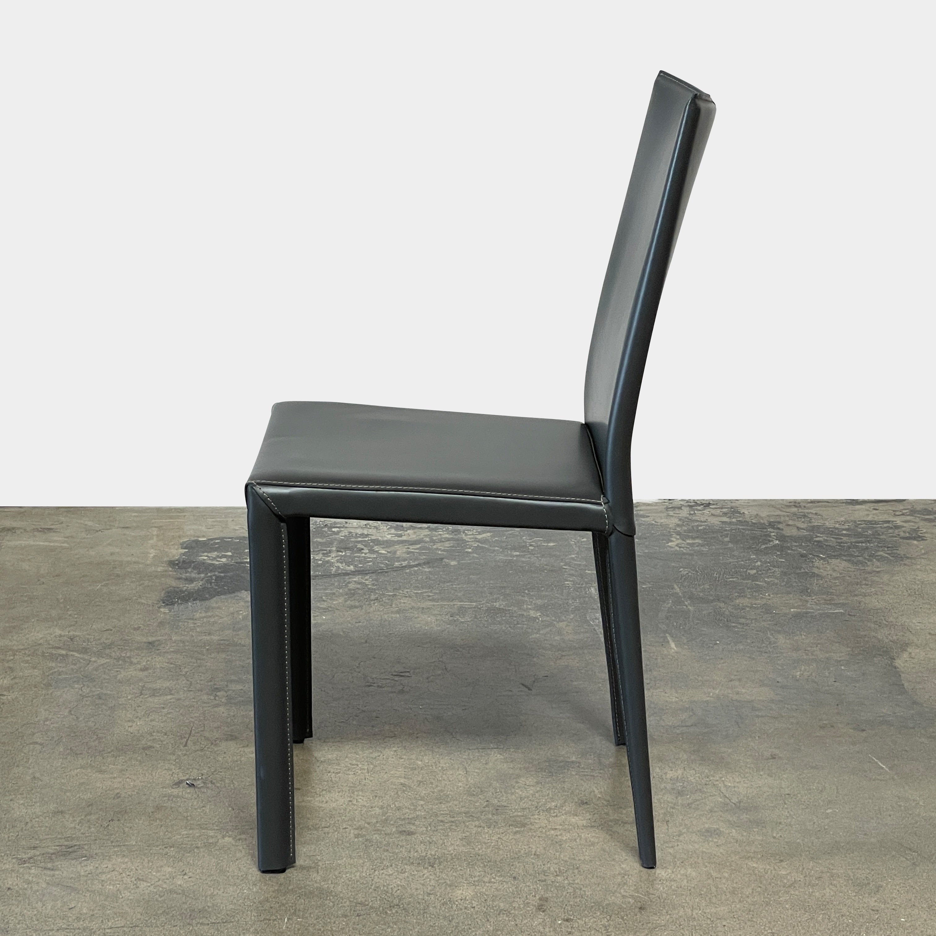 Four Frag Bella Dining Chairs in Dark Grey Leather with metal legs, arranged in a straight line against a plain white background.