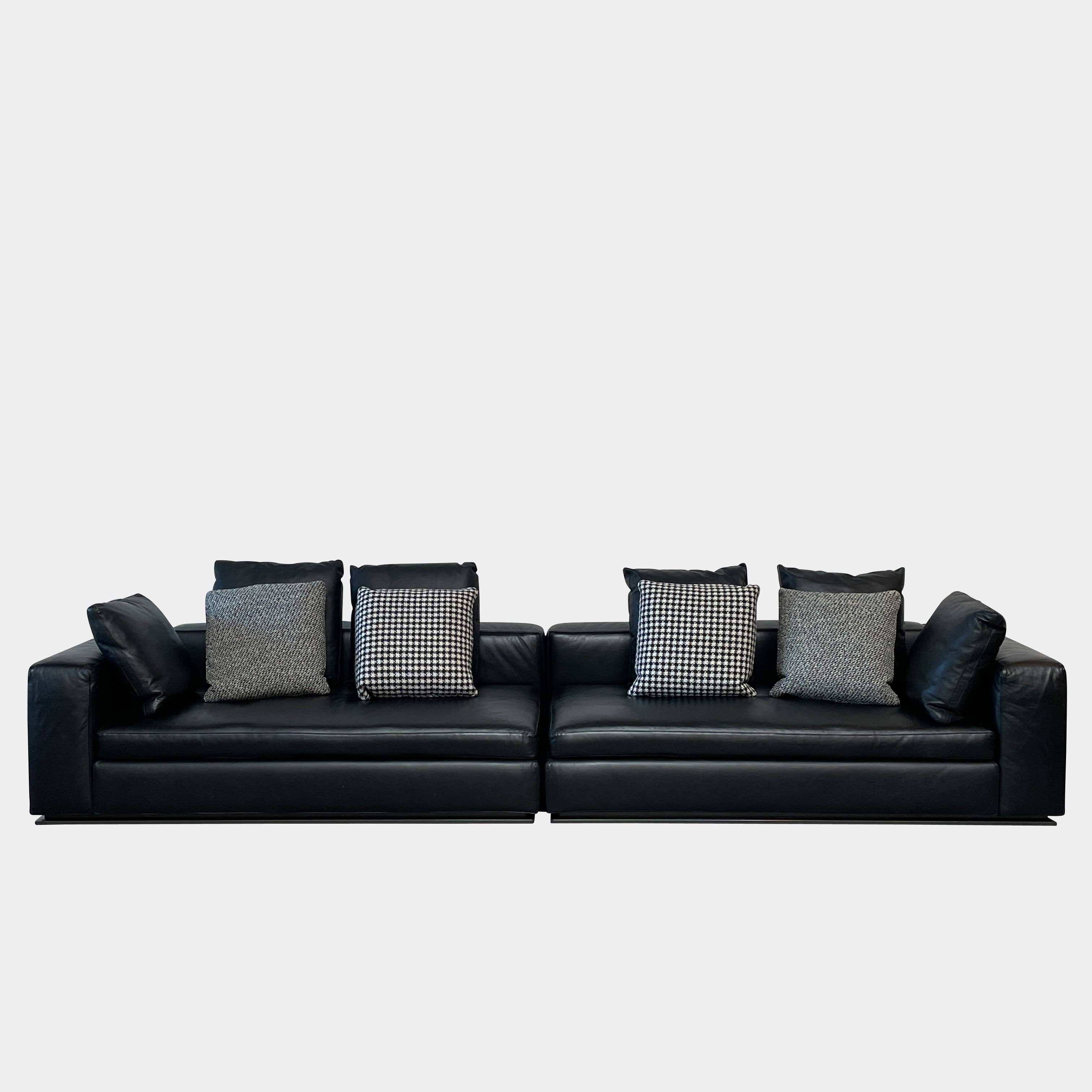 A Minotti Hamilton Black Leather Sofa with multiple cushions, designed by Rodolfo Dordoni, isolated on a white background.