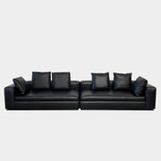 A Minotti Hamilton Black Leather Sofa with multiple cushions, designed by Rodolfo Dordoni, isolated on a white background.
