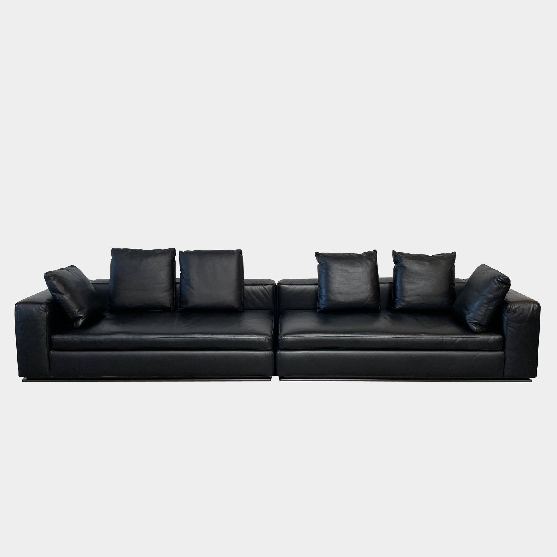 A Minotti Hamilton Black Leather Sofa with multiple cushions, designed by Rodolfo Dordoni, isolated on a white background.