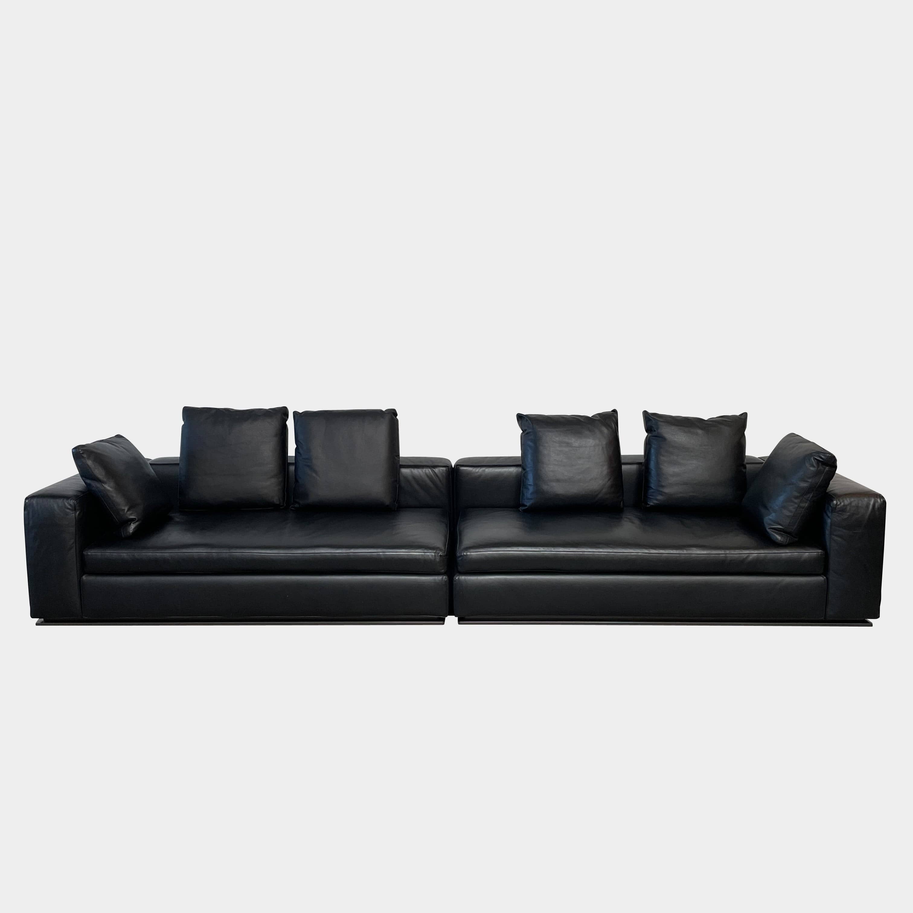 A Minotti Hamilton Black Leather Sofa with multiple cushions, designed by Rodolfo Dordoni, isolated on a white background.
