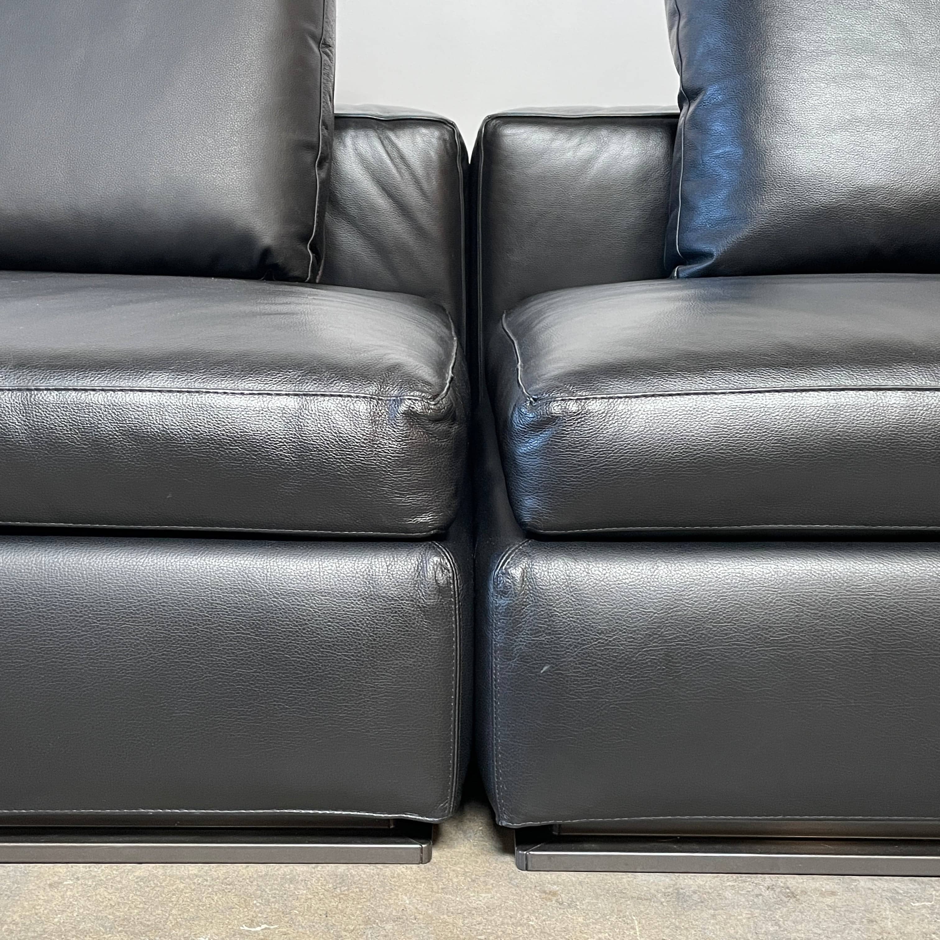 A Minotti Hamilton Black Leather Sofa with multiple cushions, designed by Rodolfo Dordoni, isolated on a white background.