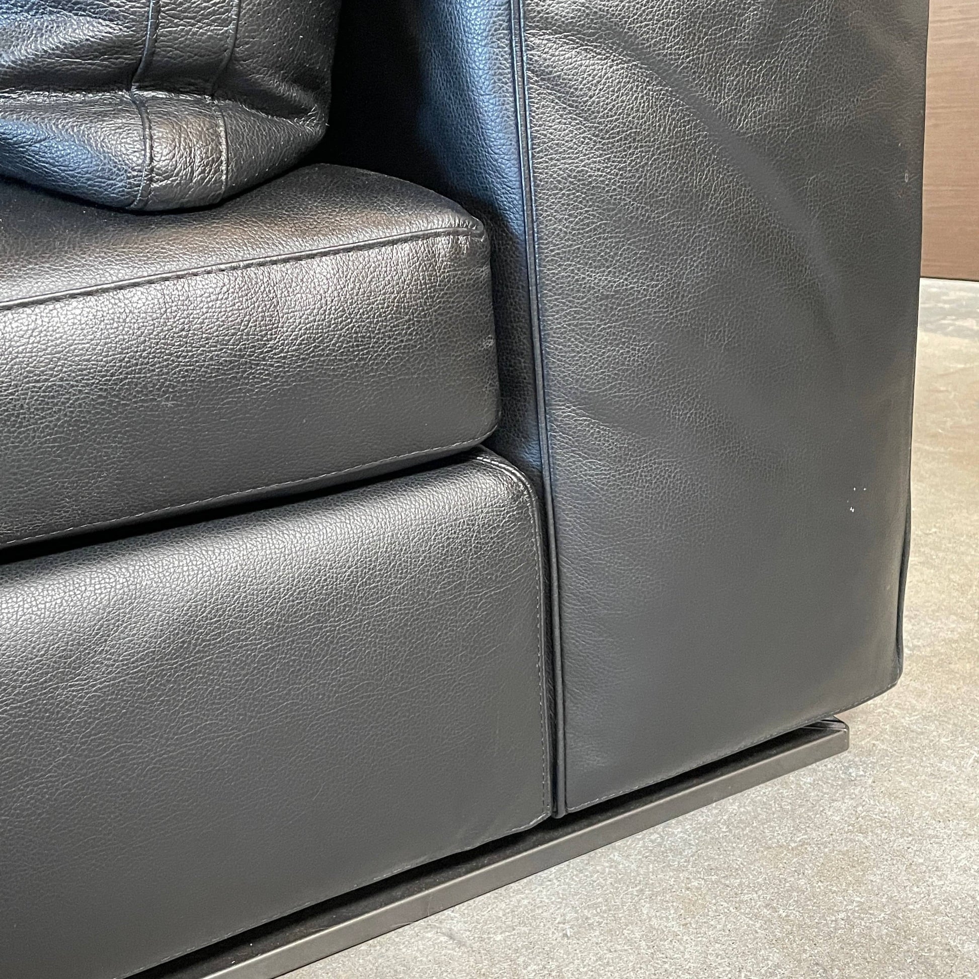 A Minotti Hamilton Black Leather Sofa with multiple cushions, designed by Rodolfo Dordoni, isolated on a white background.